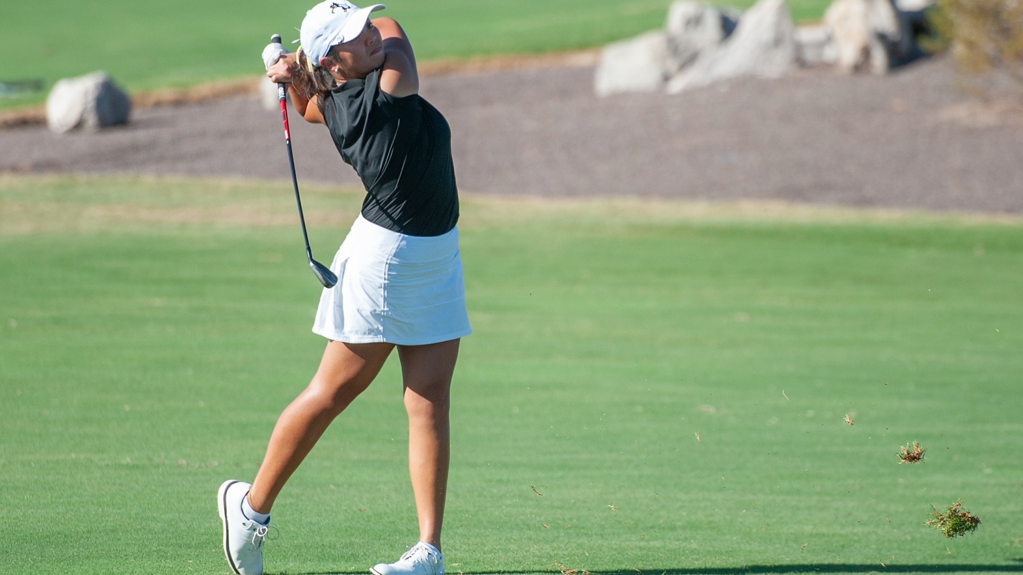 Faith Guevara watches an iron shot from the fairway