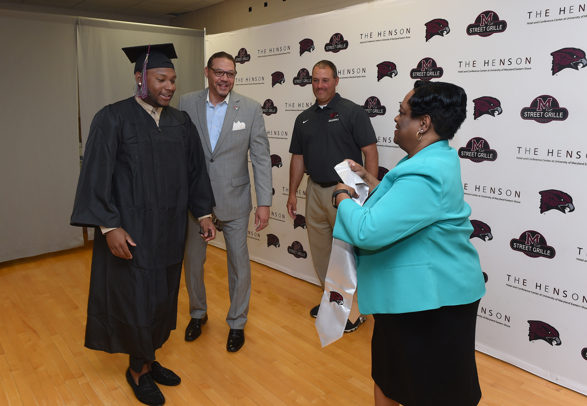 School president Dr. Juliette B. Bell presents baseball senior Jamison Trower with his student-athlete sash as Director of Athletics Keith Davidson and Head Baseball Coach Brian Hollamon look on