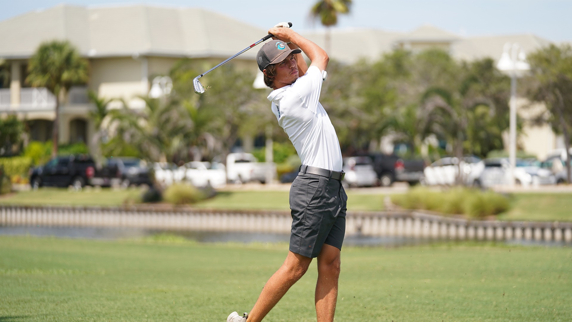 men's golfer swinging iron on a fairway shot