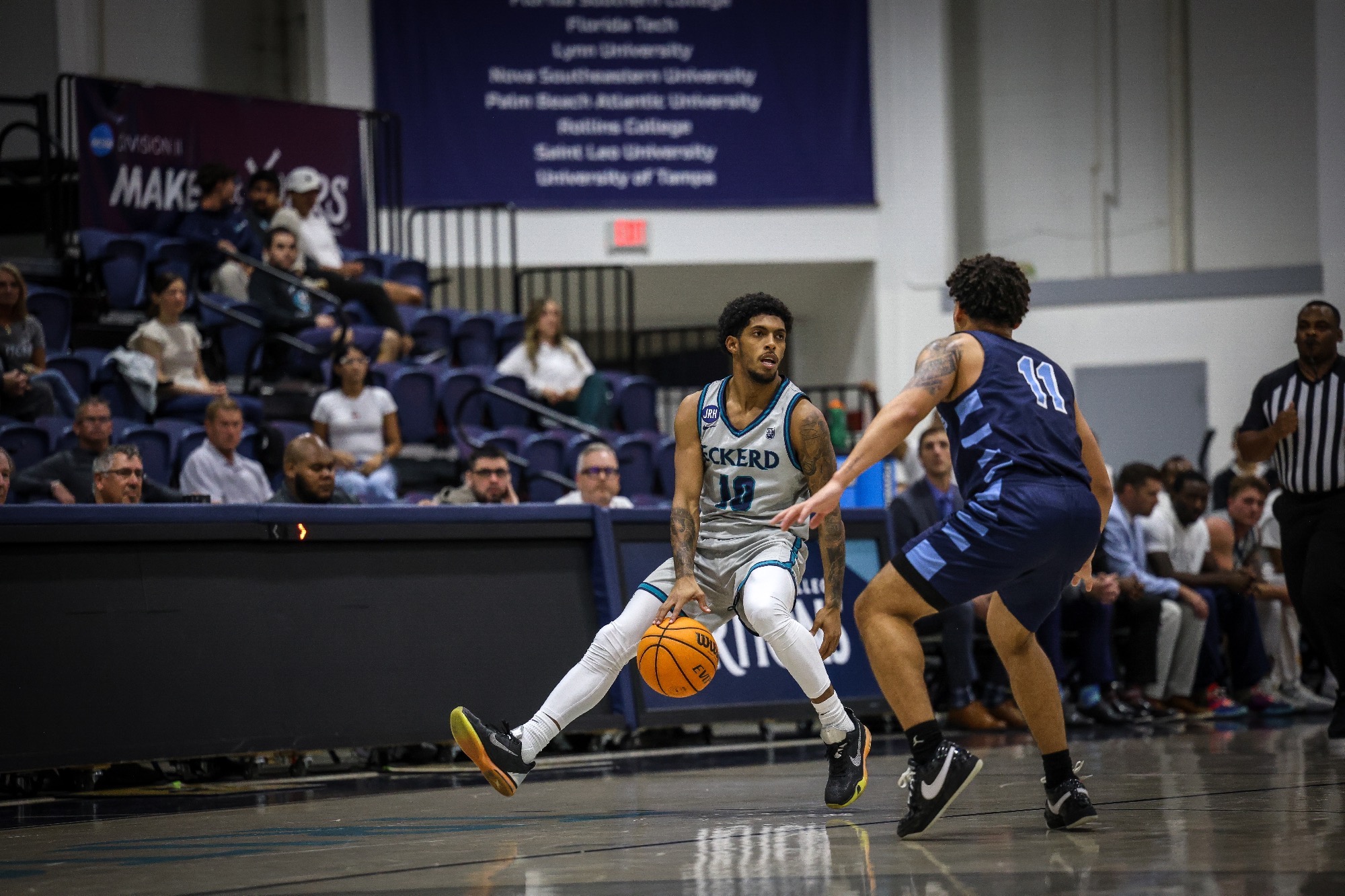 Player dribbles ball up floor and is being guarded by defender