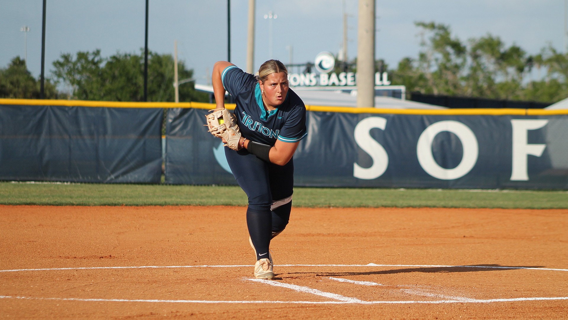 softball player getting signal for pitch 