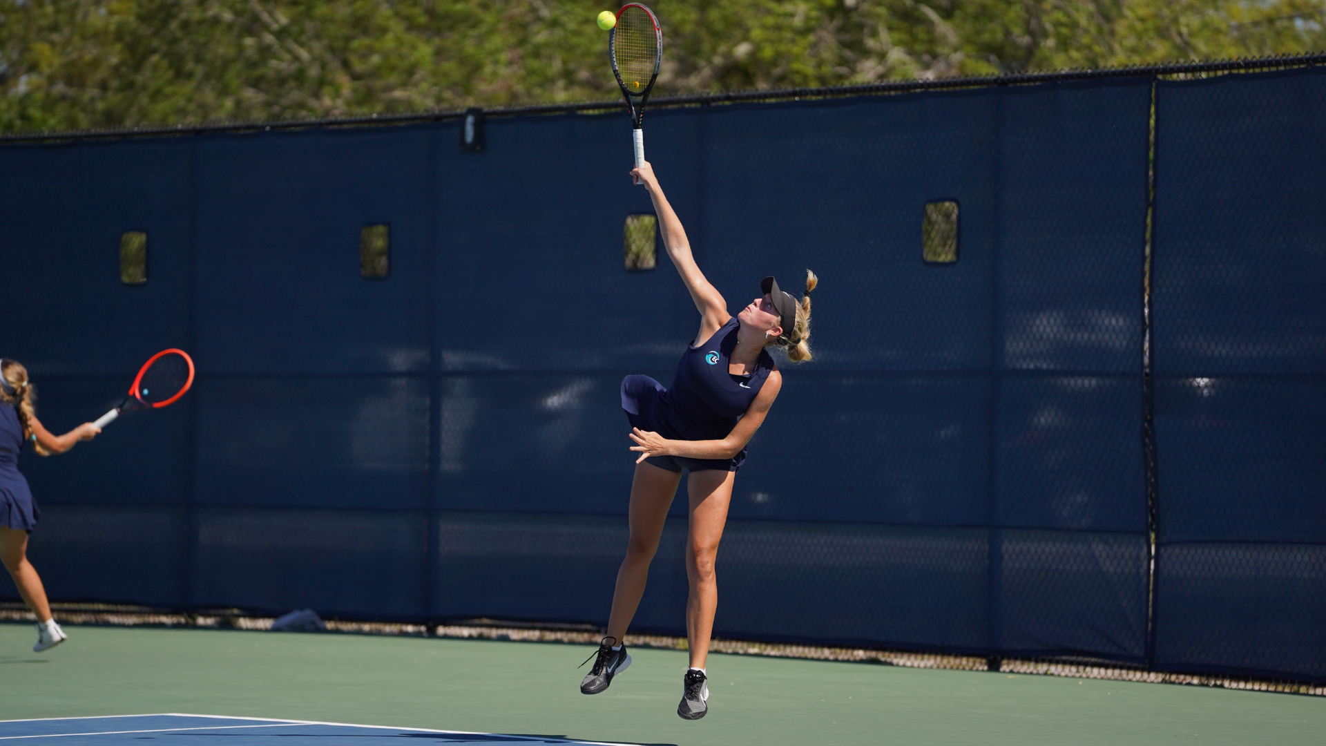 Cate Cole hits a serve