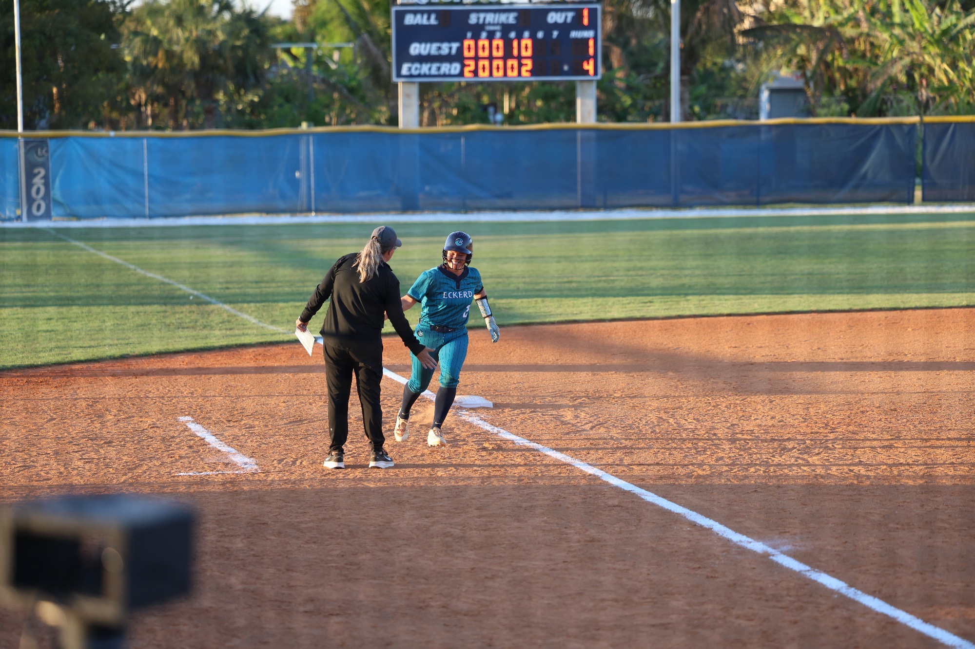 player high fives coach after home run