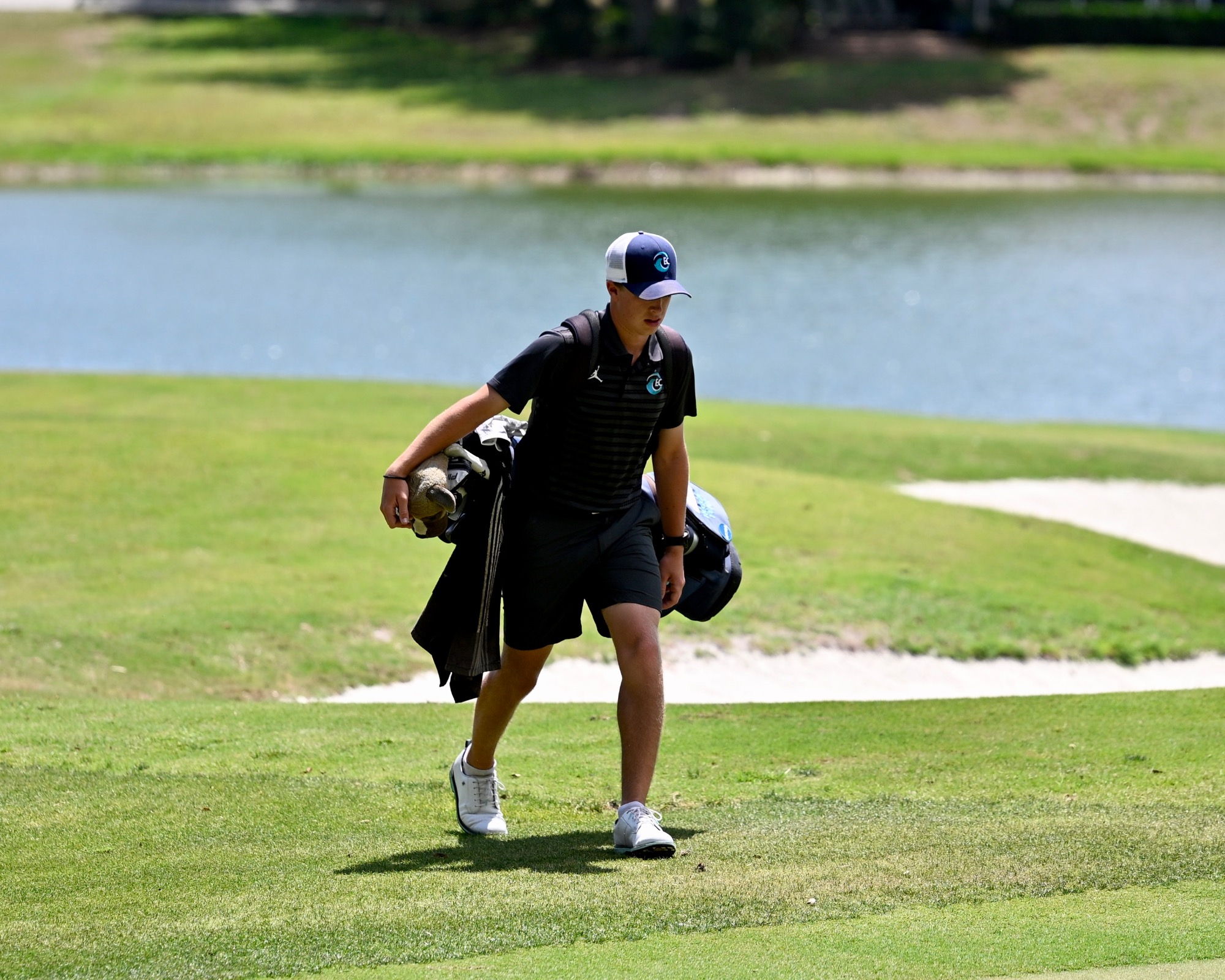 player walks with golf bag