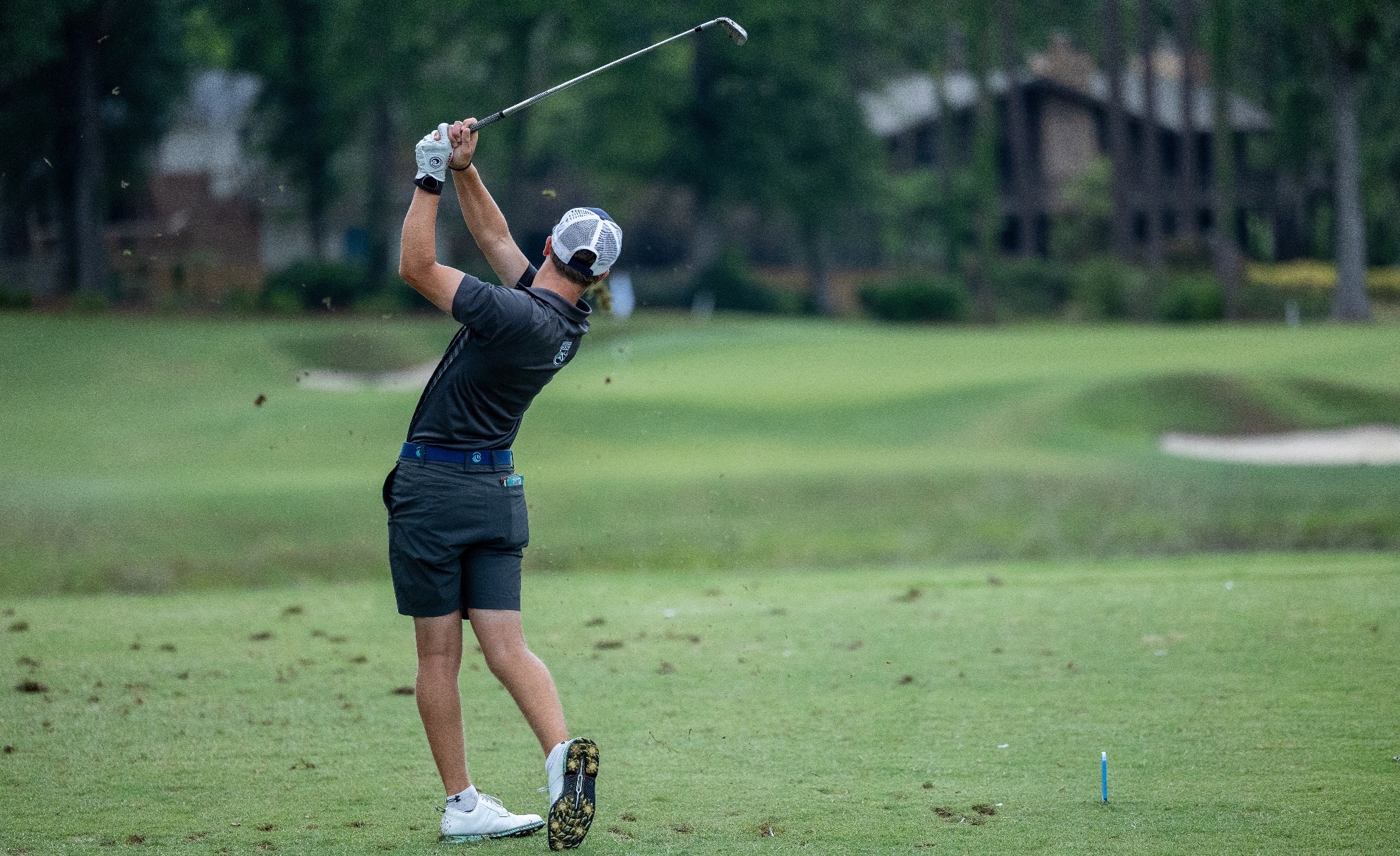 player tees off