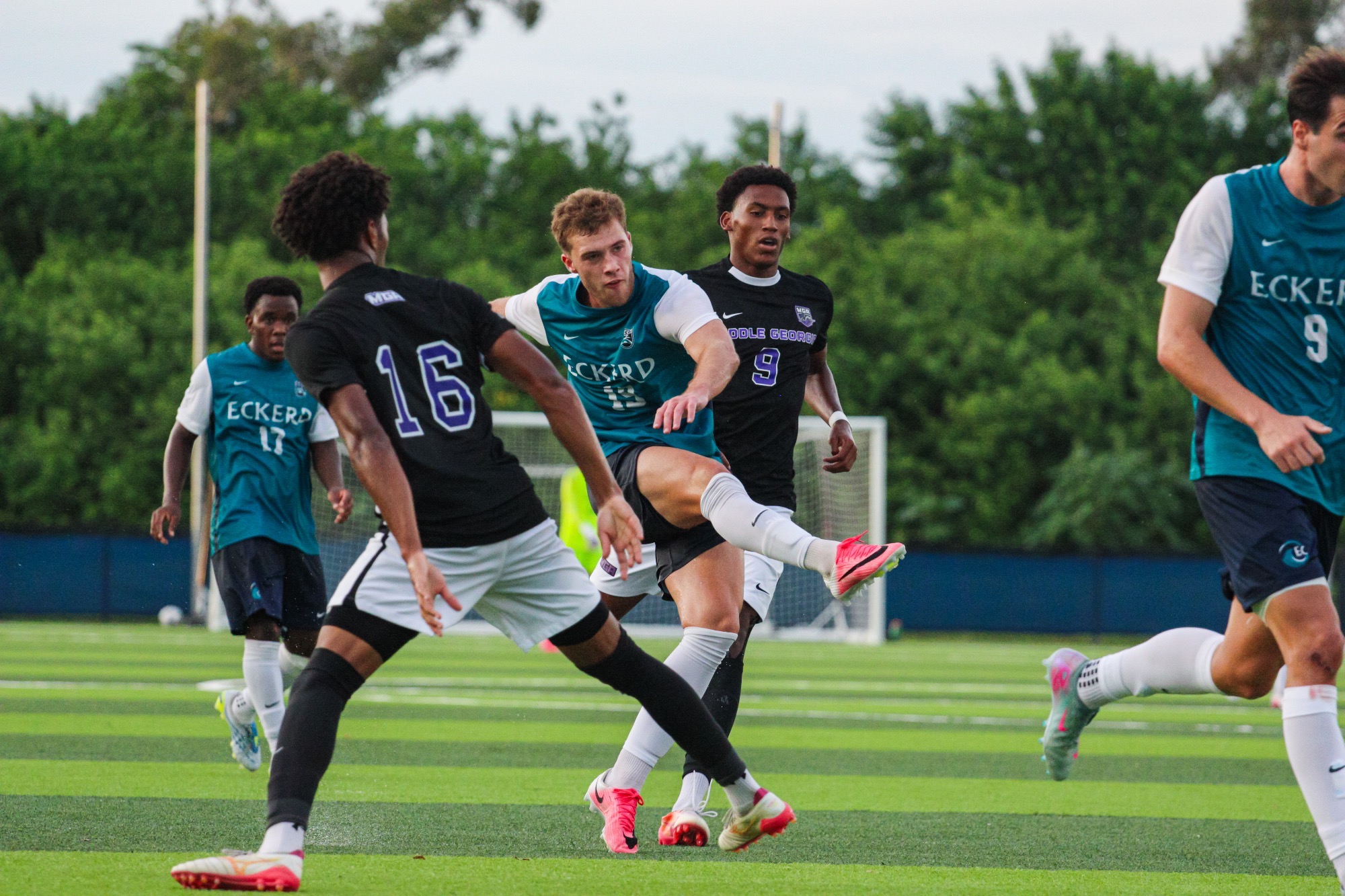 player kicking ball past defenders