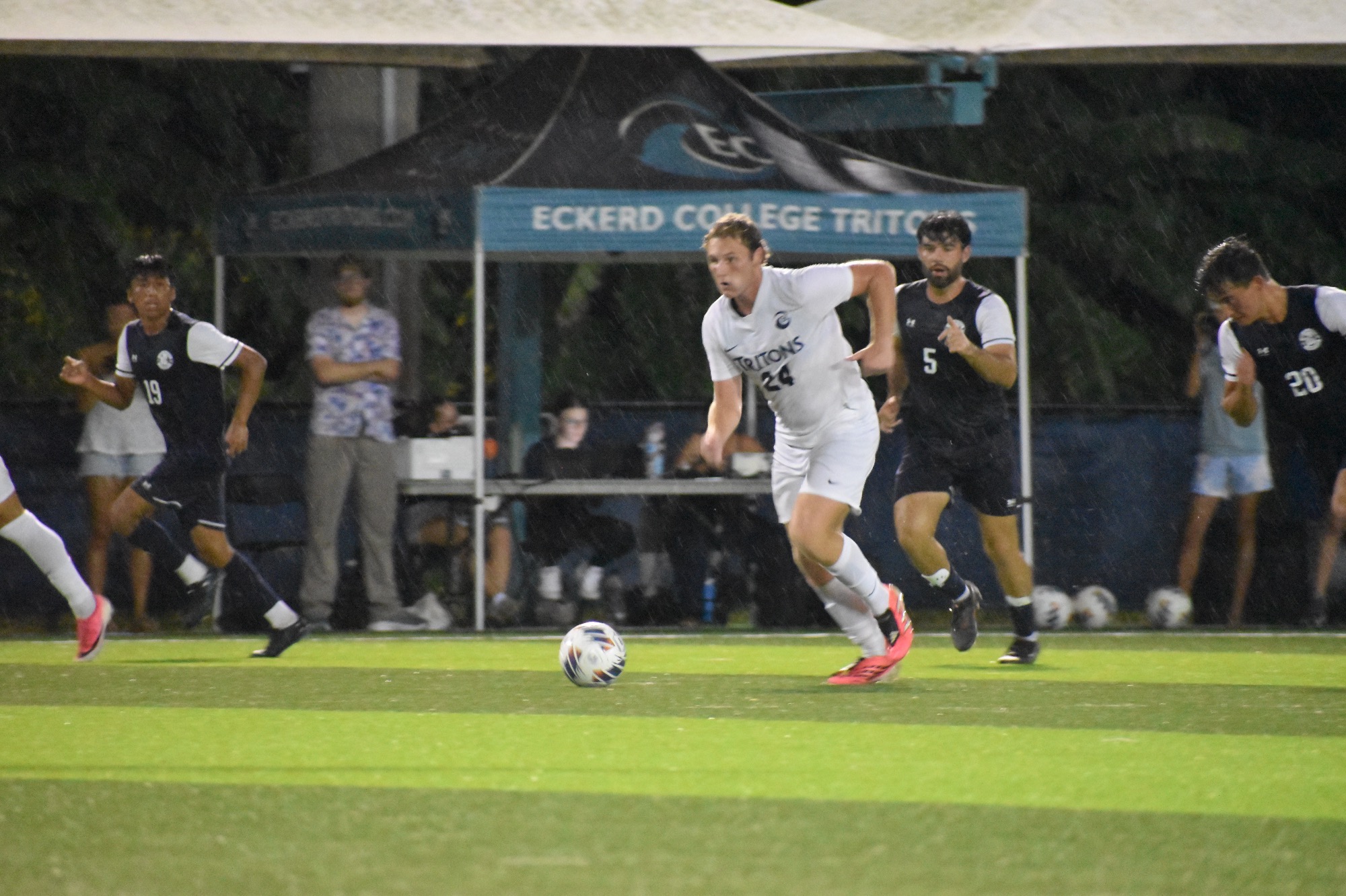 player running in rain with ball
