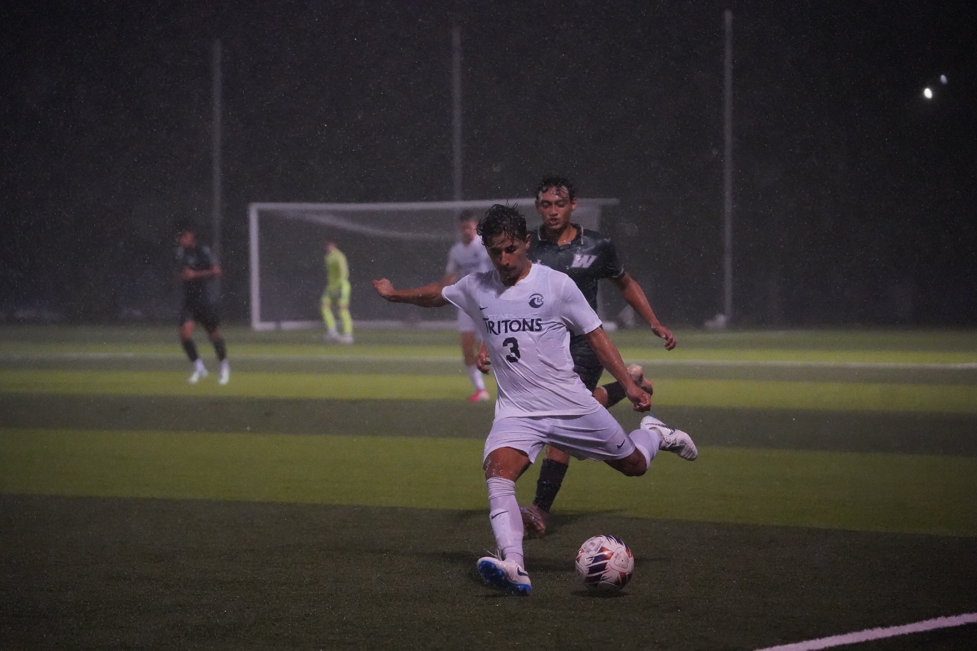 player kicks ball in rain