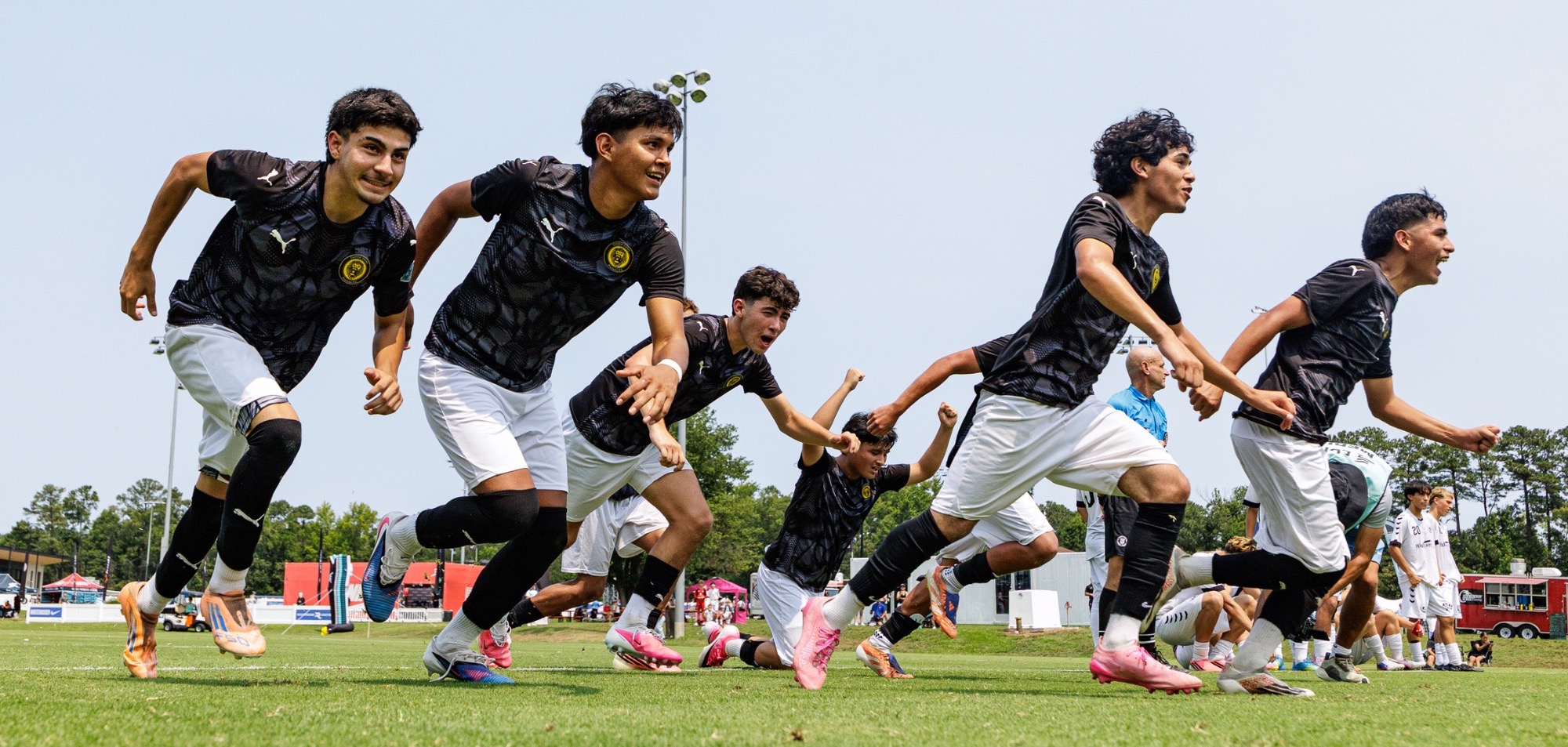 Players celebrate after a penalty kick victory at the ECNL RL Boys National Finals