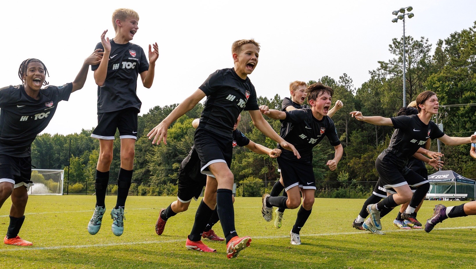 Players celebrate after winning in penalties at the ECNL RL Boys National Finals