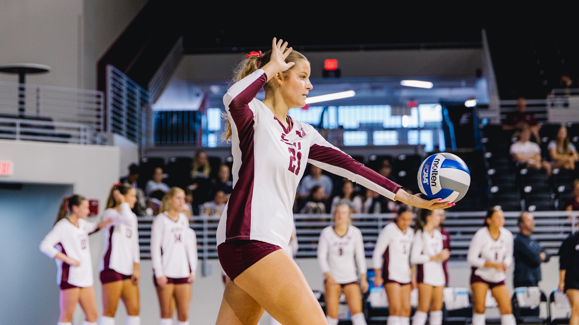 Addison Burke prepares to serve against Presbyterian College