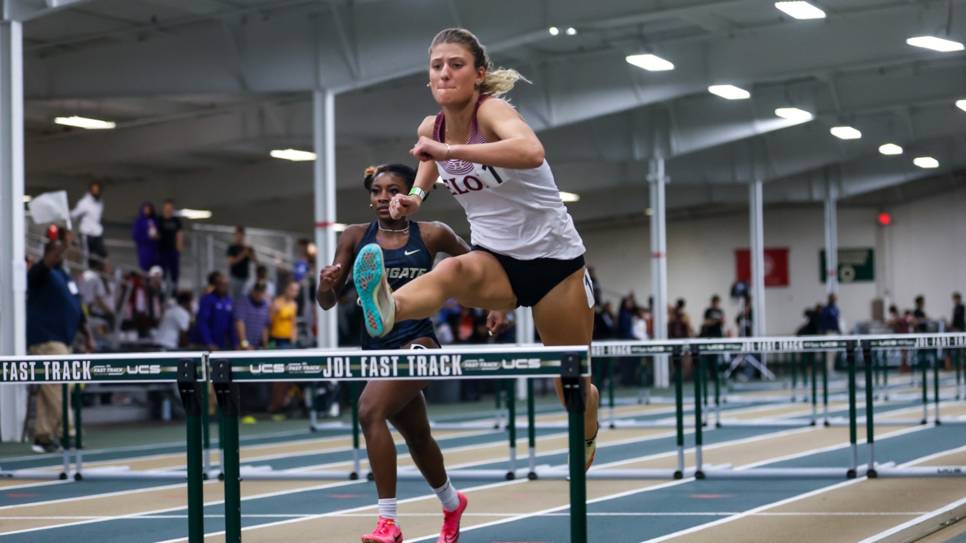Lizzie Lopez going over a hurdle during indoor season