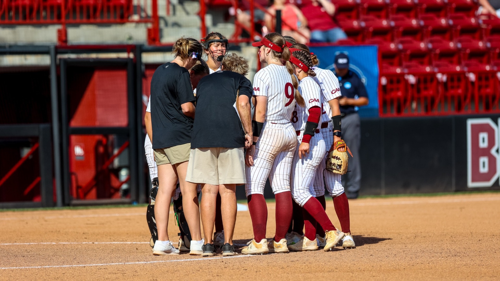 Elon softball team huddle versus Virginia on May 17