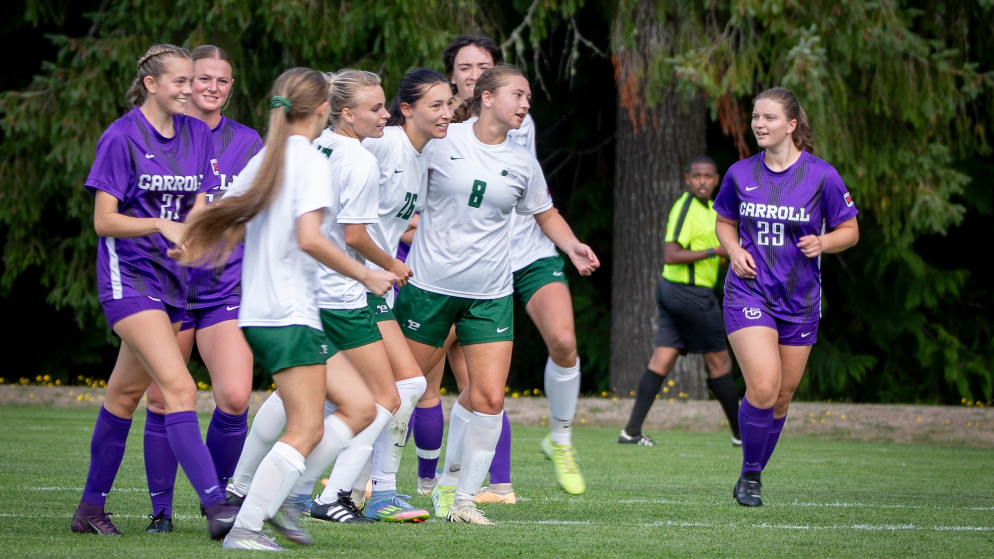 Madeline Dorendorf (#26, in middle of group) celebrates with teammates after scoring a goal.