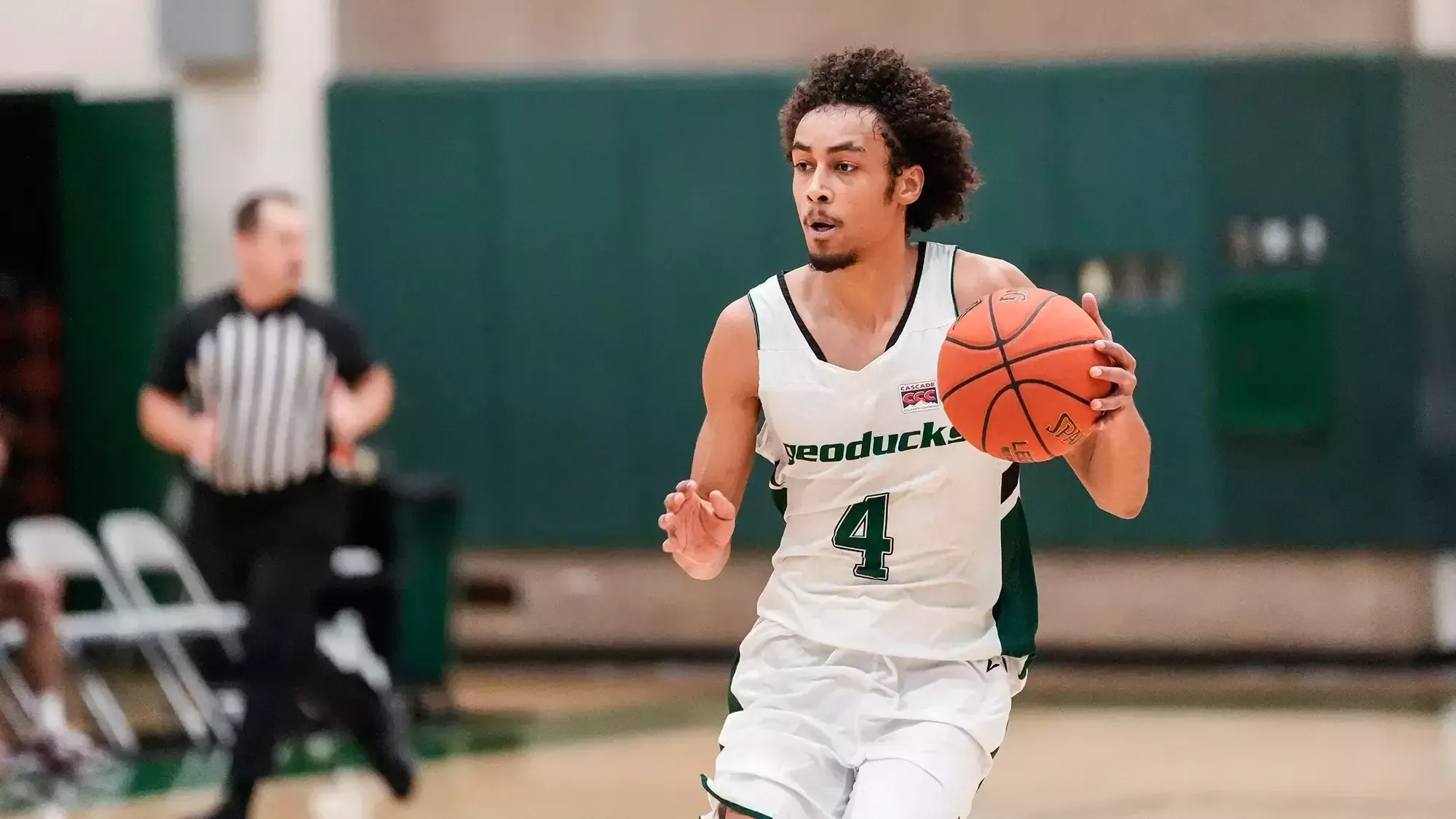Tony Frohlich-Fair dribbles the basketball for the Evergreen Geoducks.