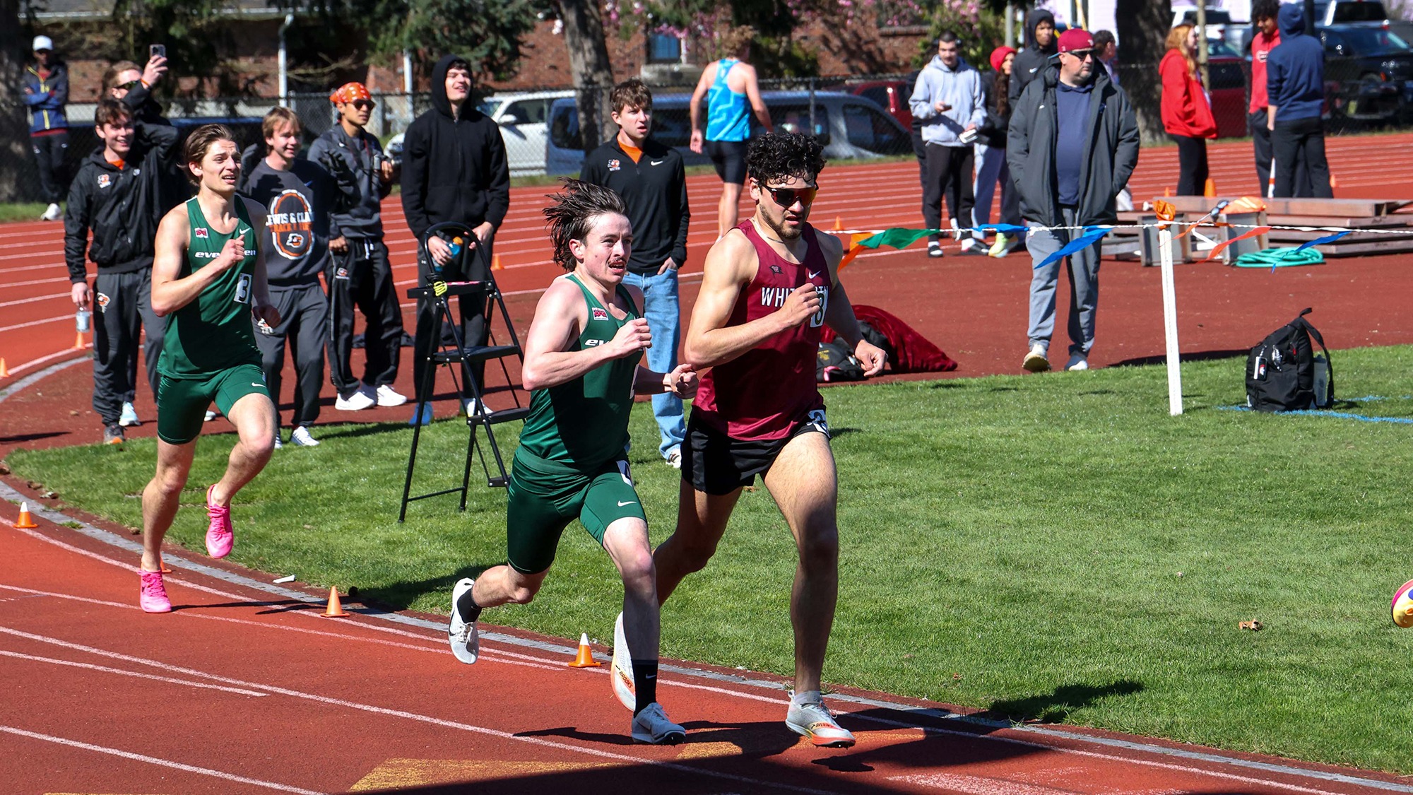 Jackson Rye (middle, wearing green) and Evan Williams (left, wearing #3) run for Evergreen.