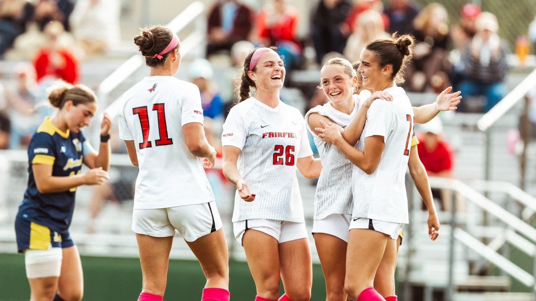 Women's Soccer celebrates after a goal against Merrimack