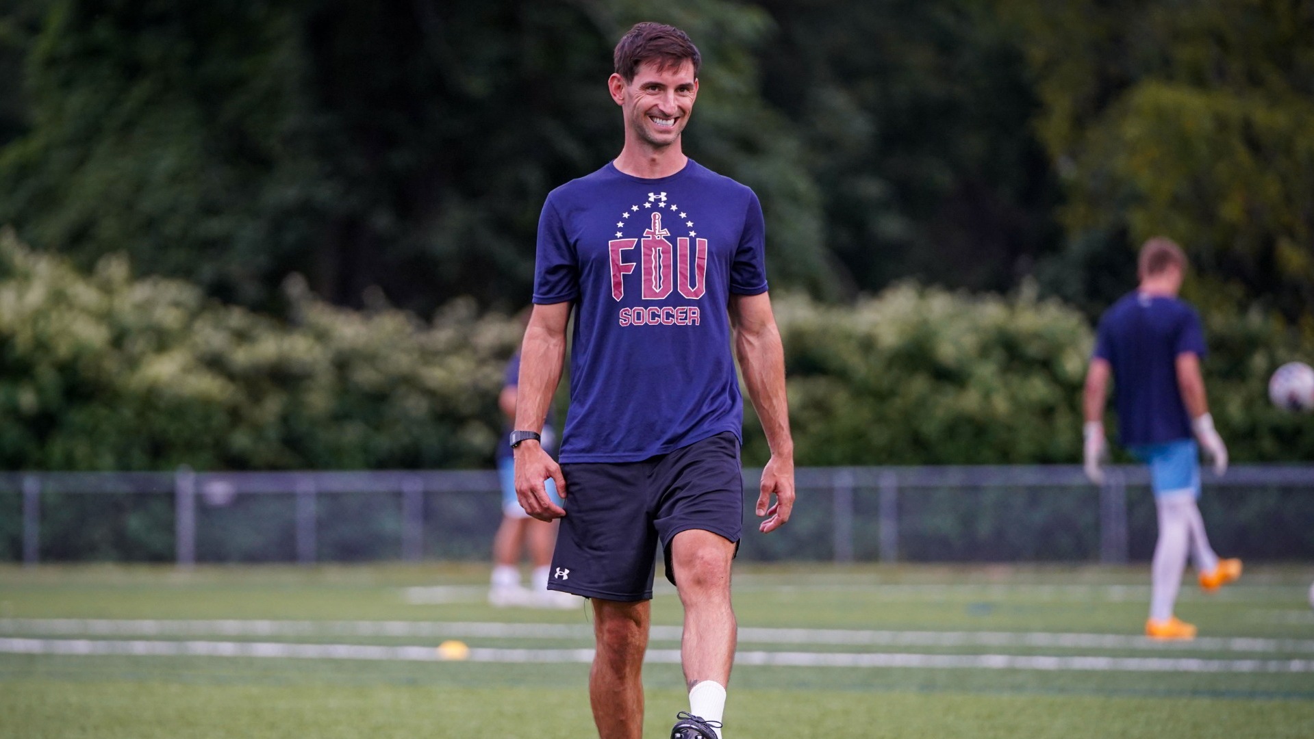 Jaymee Highcock stands on top of soccer ball.