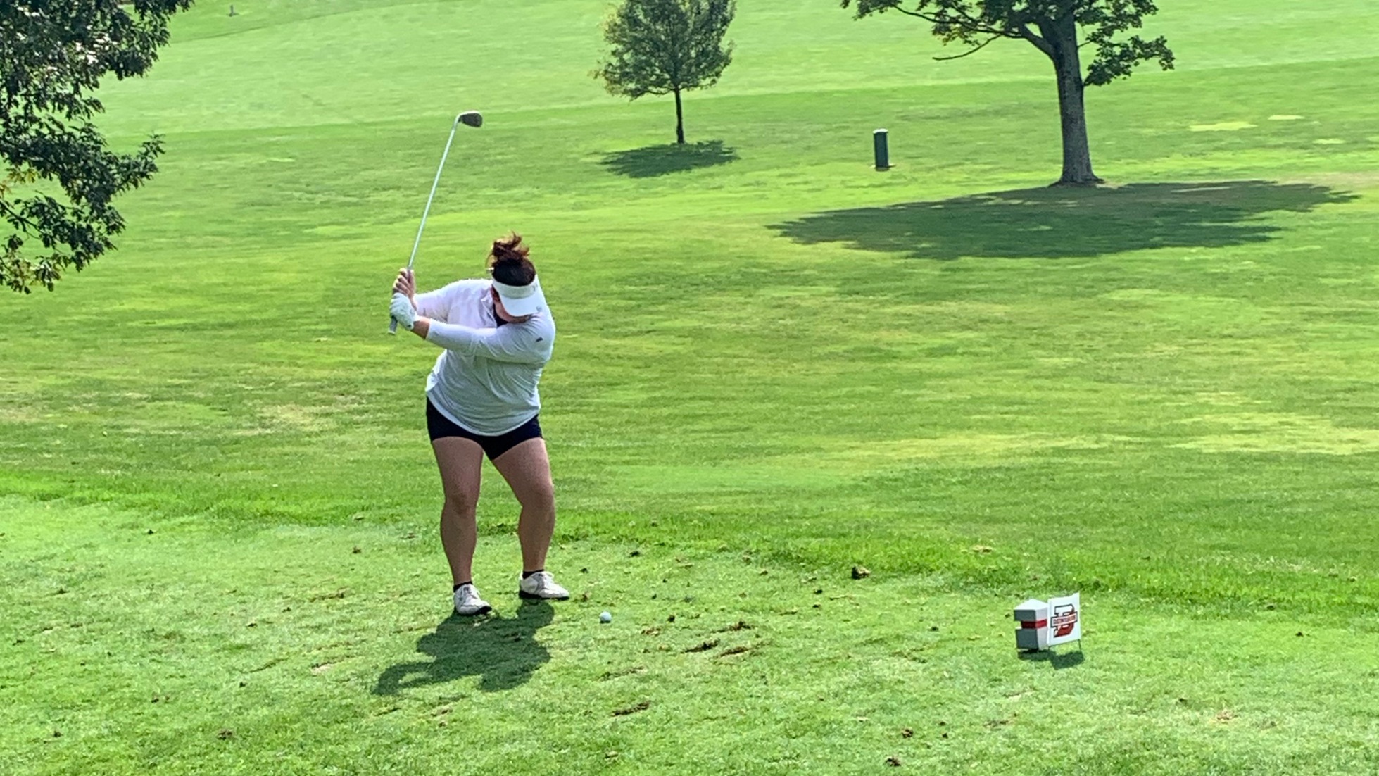 King brings the club back as she gets ready to swing and hit the ball