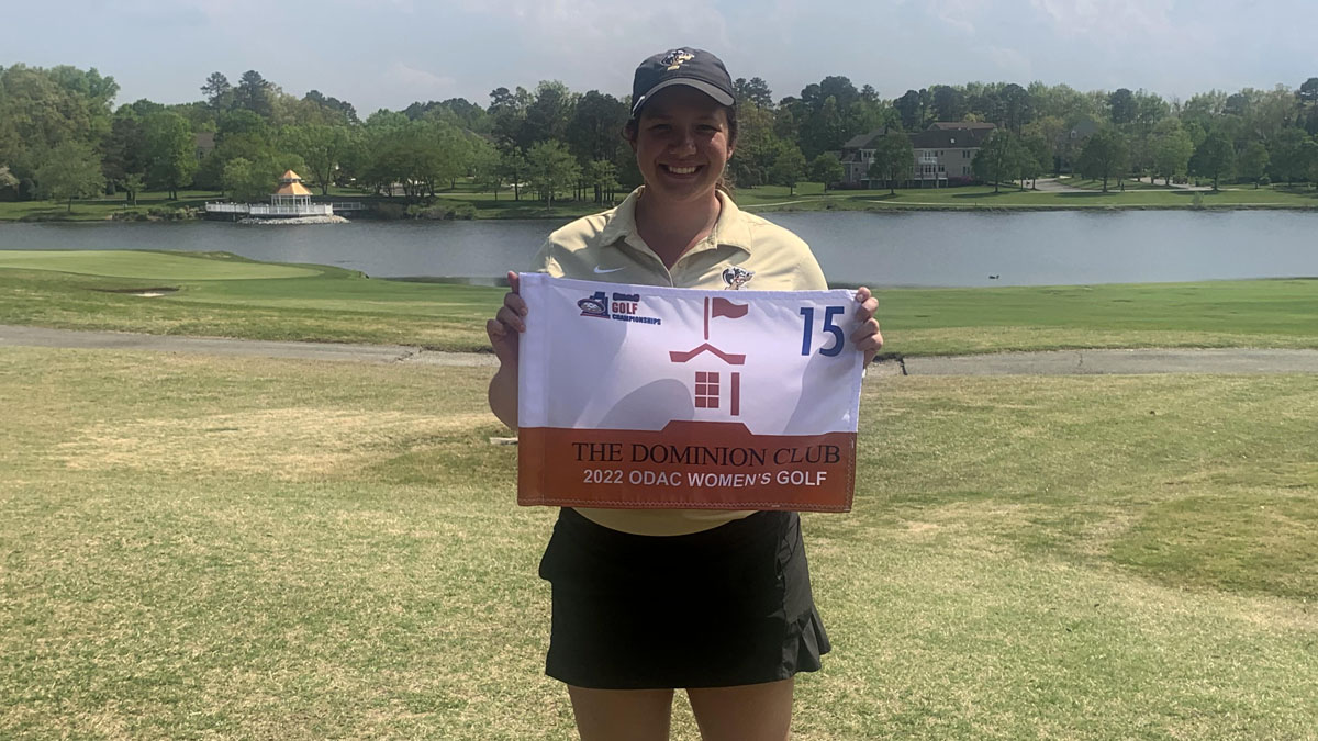 Hunter Tharpe poses with a pin flag after placing in the top 18 at the ODAC tournament 