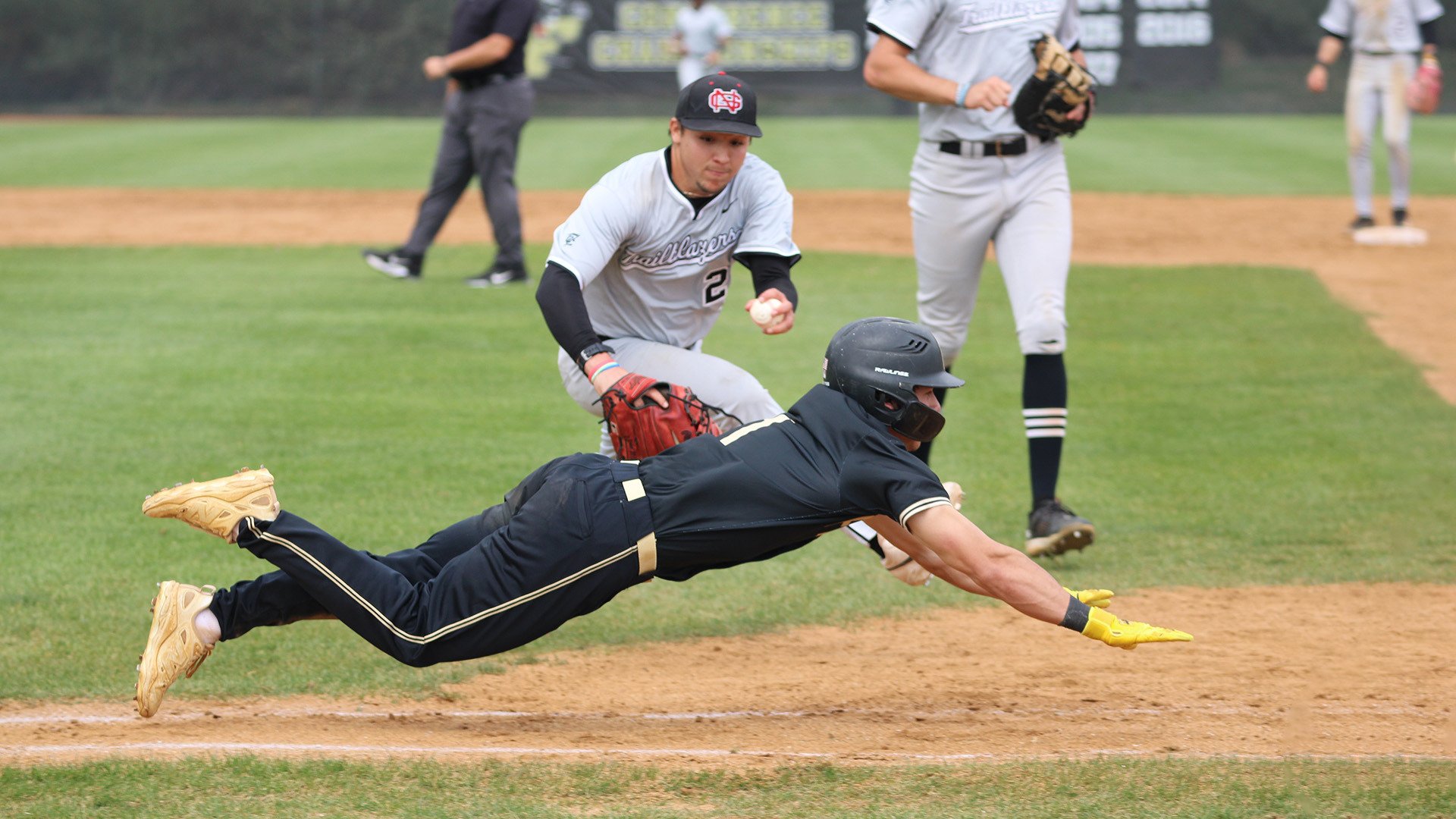 Tyler Mason with a bunt single head-first slide into first base during a home game on March 27, 2026. 