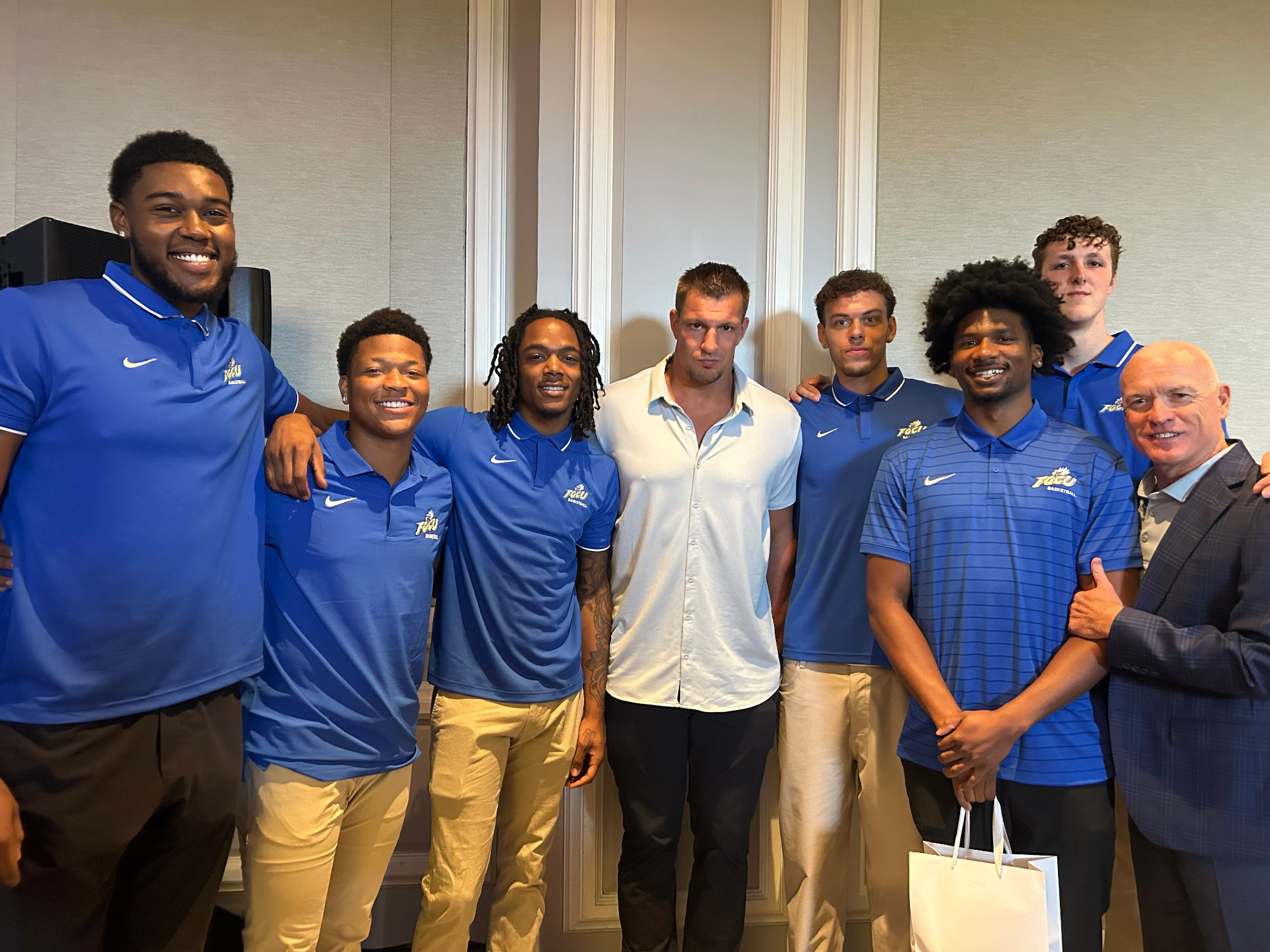 Rob Gronkowski poses for a photo with FGCU men's basketball players