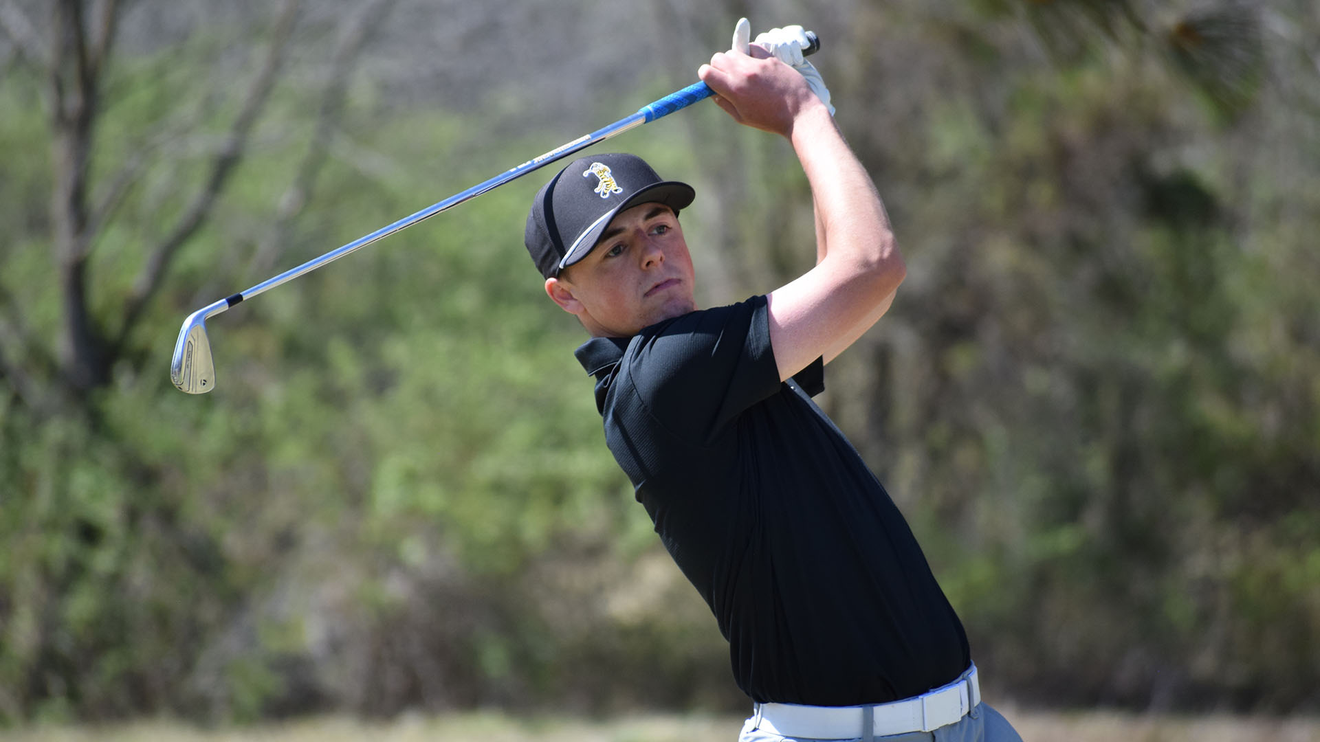 Isaak Bowman hits an iron shot during a golf tournament