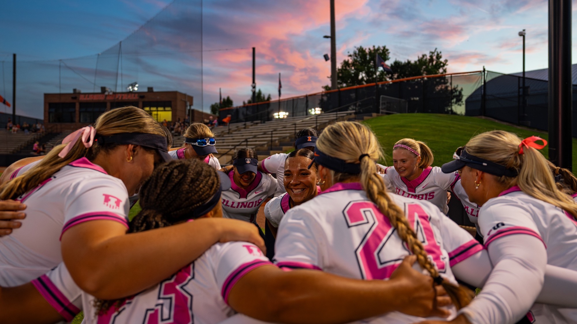 Softball huddles together before a fall game