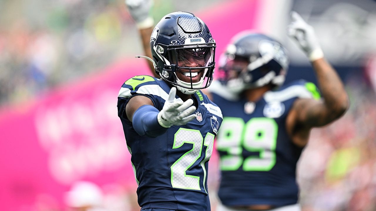 Devon Witherspoon flashes a big smile and gives a thumbs up to fans while wearing his Seattle Seahawks #21 uniform during the game.