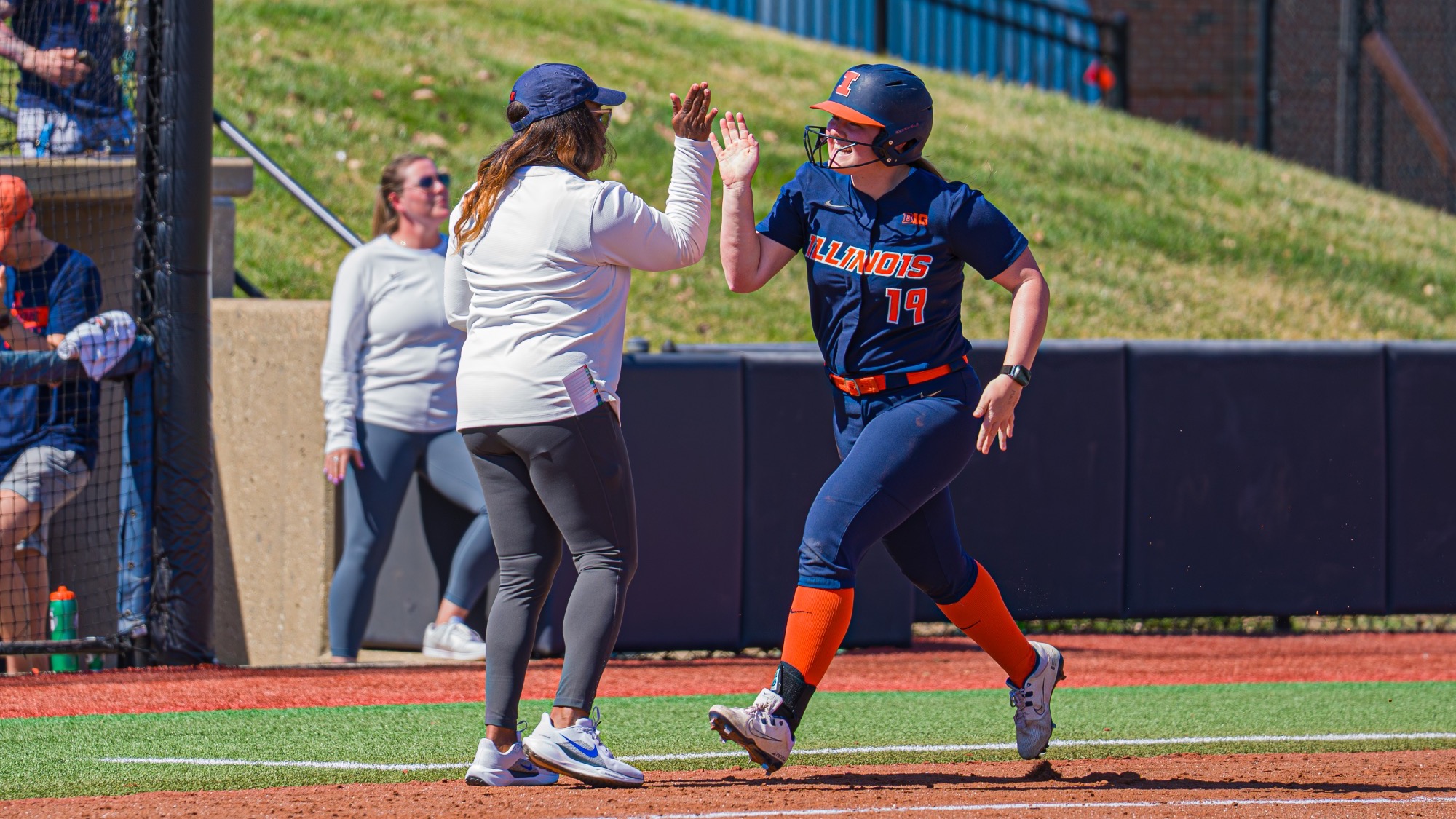 Eileen Donahue high-fives head Coach Tyra Perry after a home run