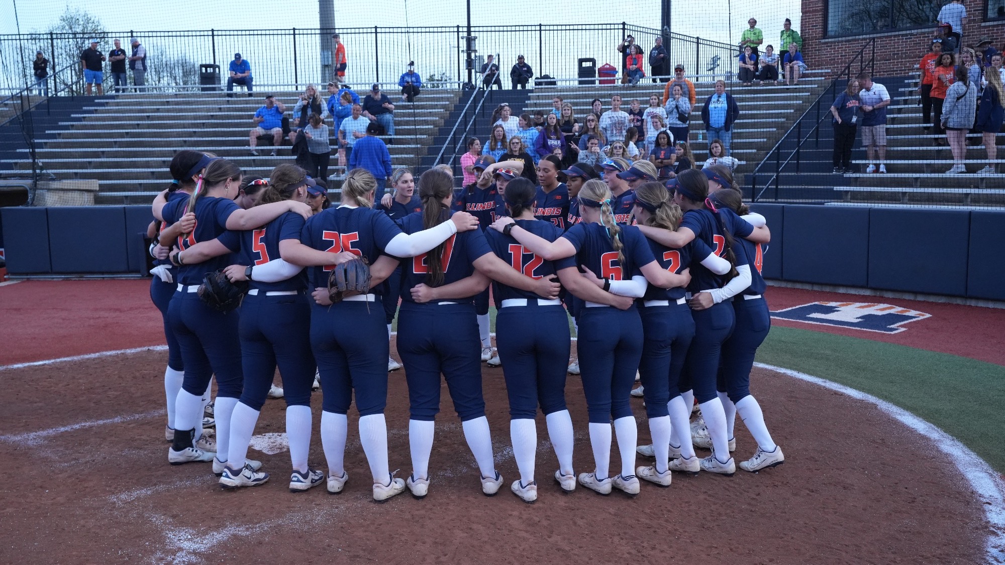 Illinois softball huddles on Eichelberger Field in Urbana, Illinois.