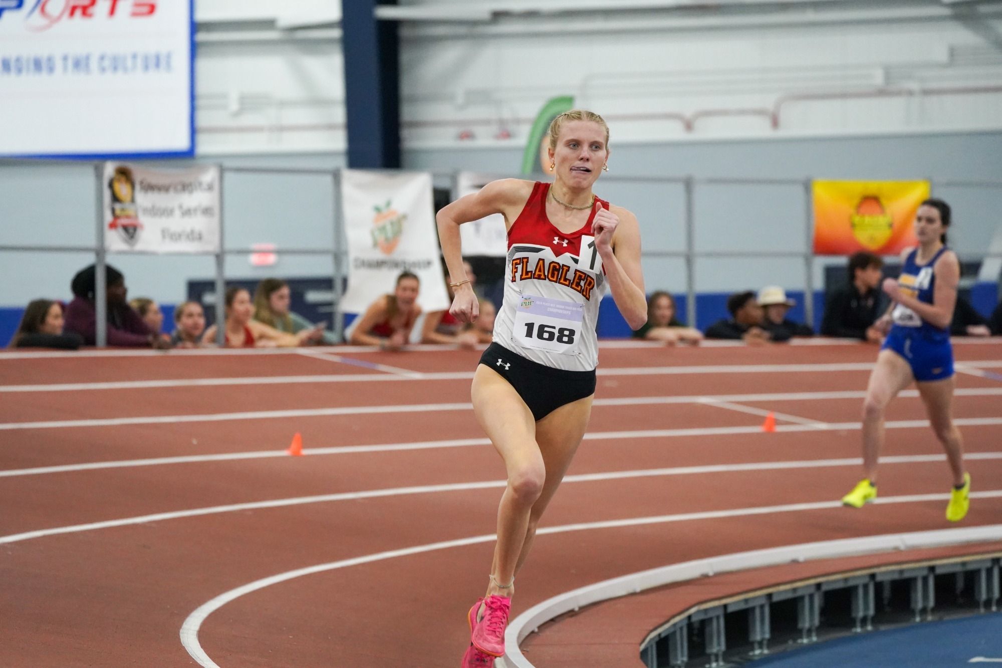 Abby Misch running around the turn on the track at the PBC Indoor Championship.
