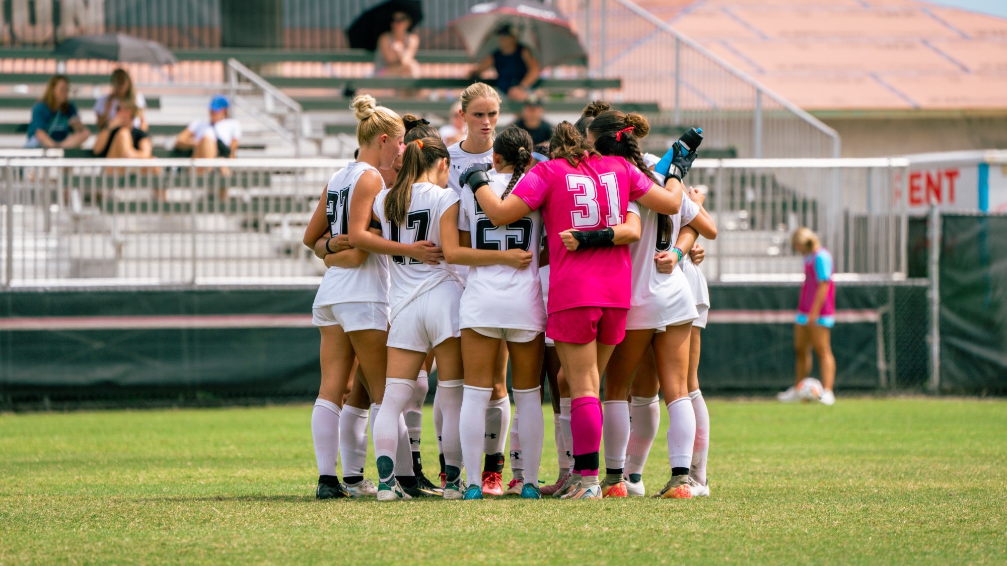 Women's soccer starters huddle before the match