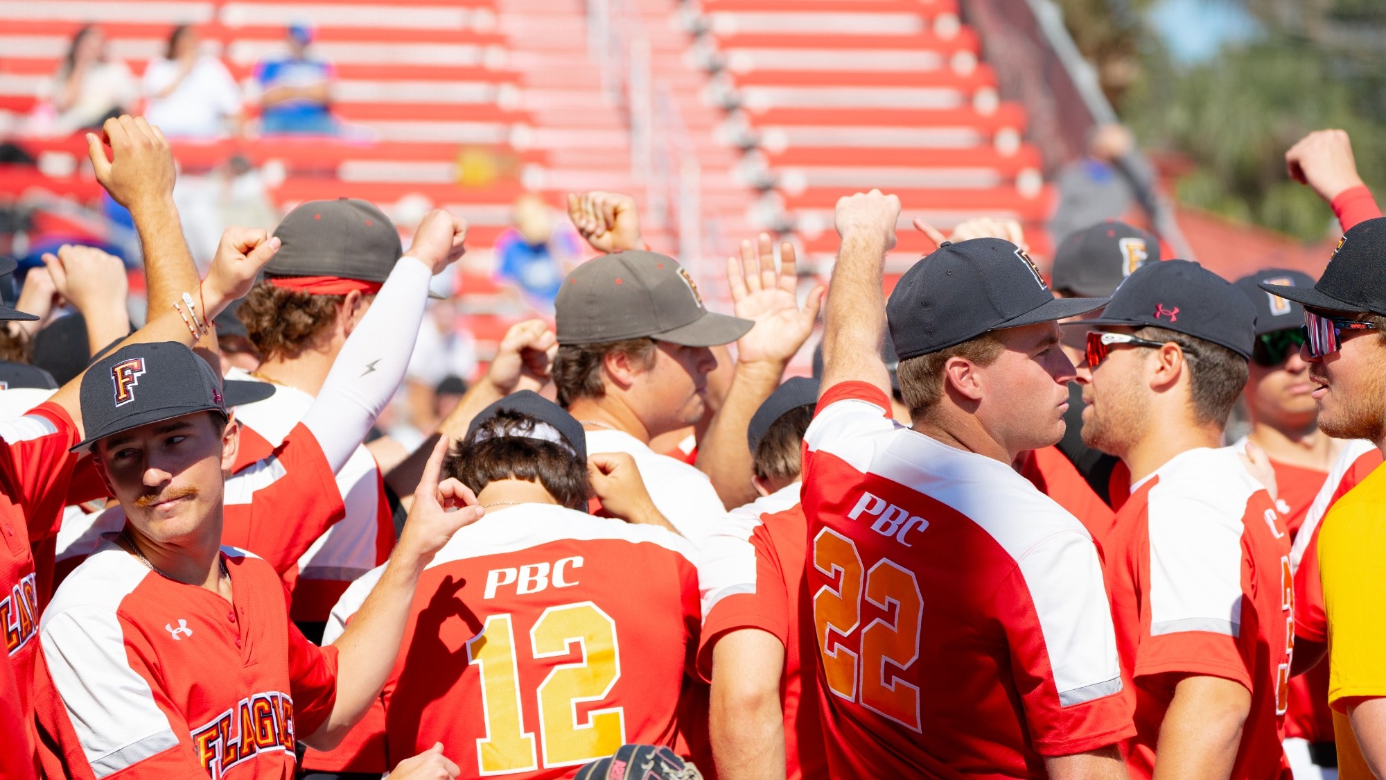 Flagler players break a huddle in front of the dugout