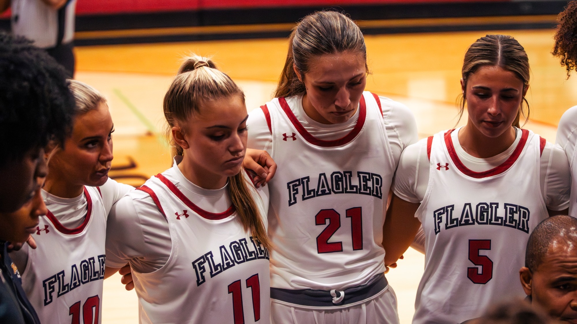 Women's basketball players stand during a tmeout