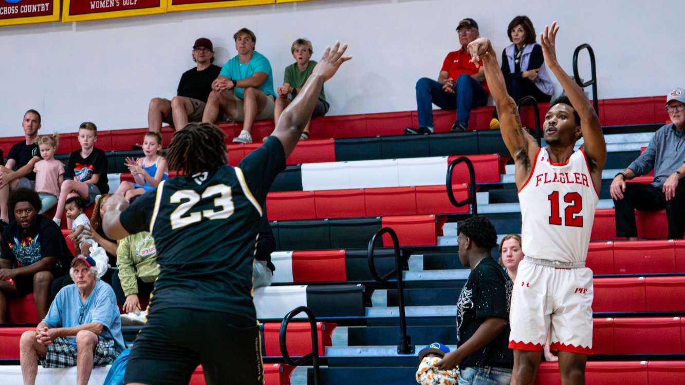 Rahdir Hicks shoots a three-pointer with a defender coming towards him