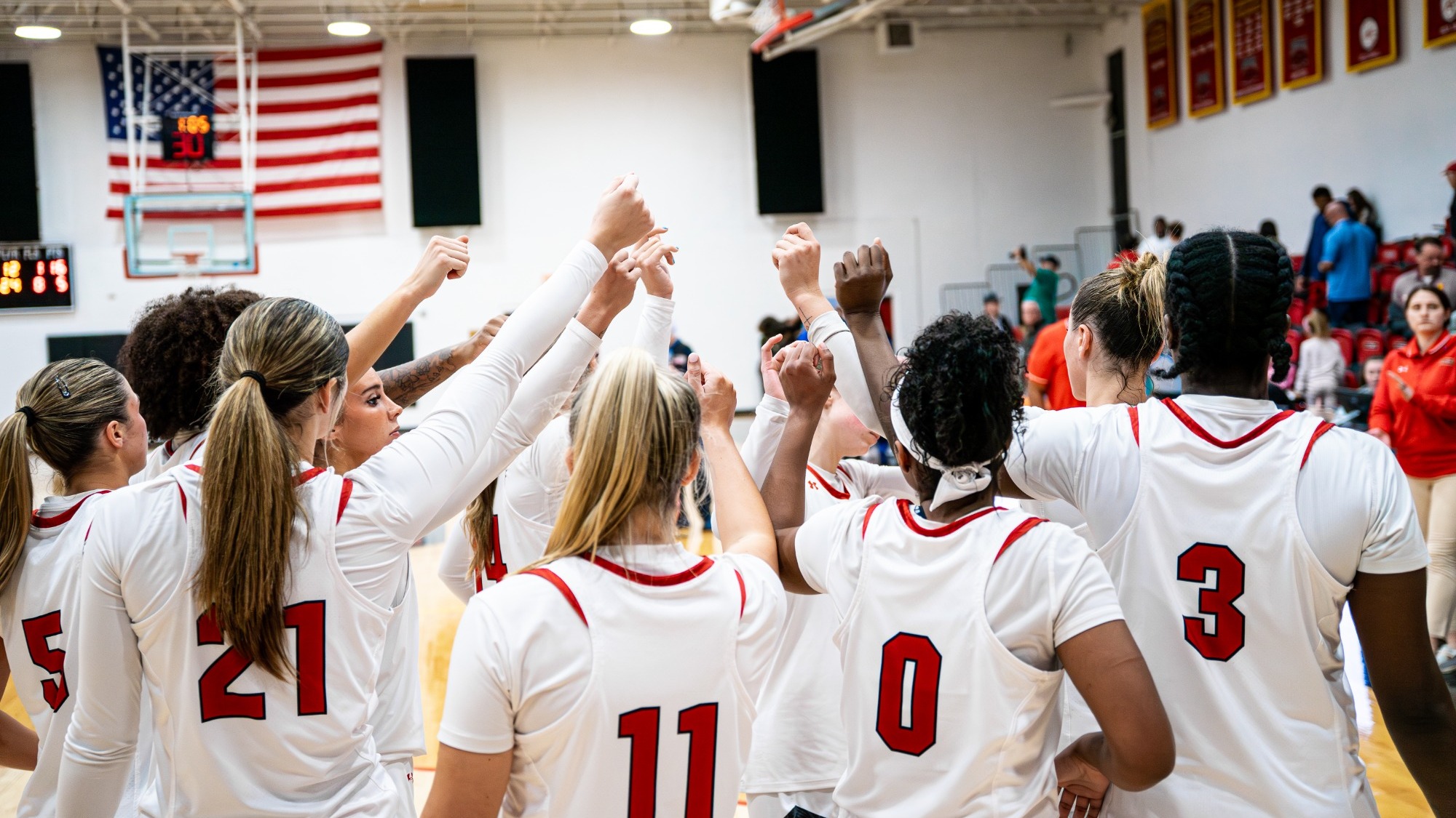 Women's basketball players breaking the huddle