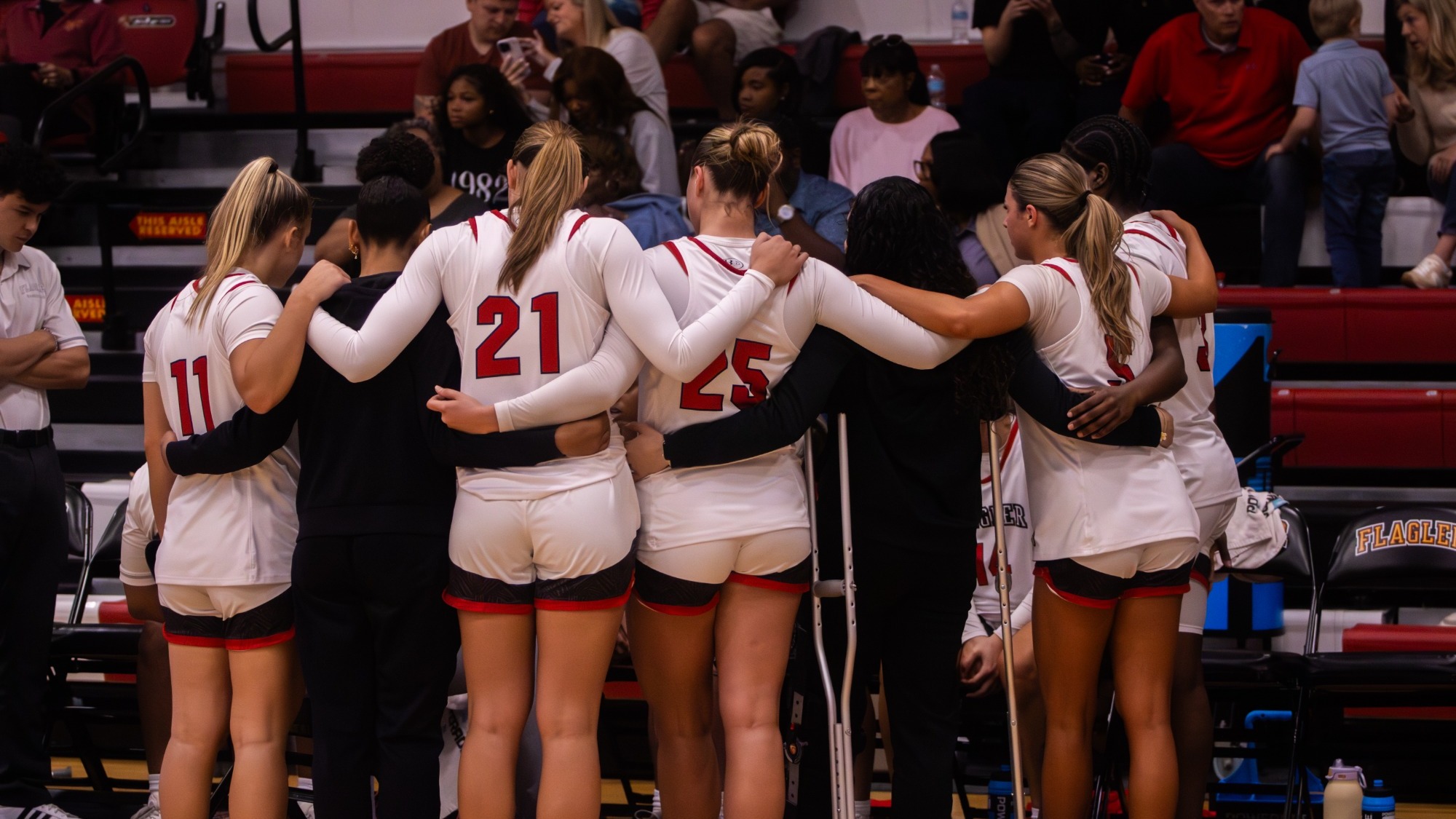 Women's basketball team huddles during a timeout