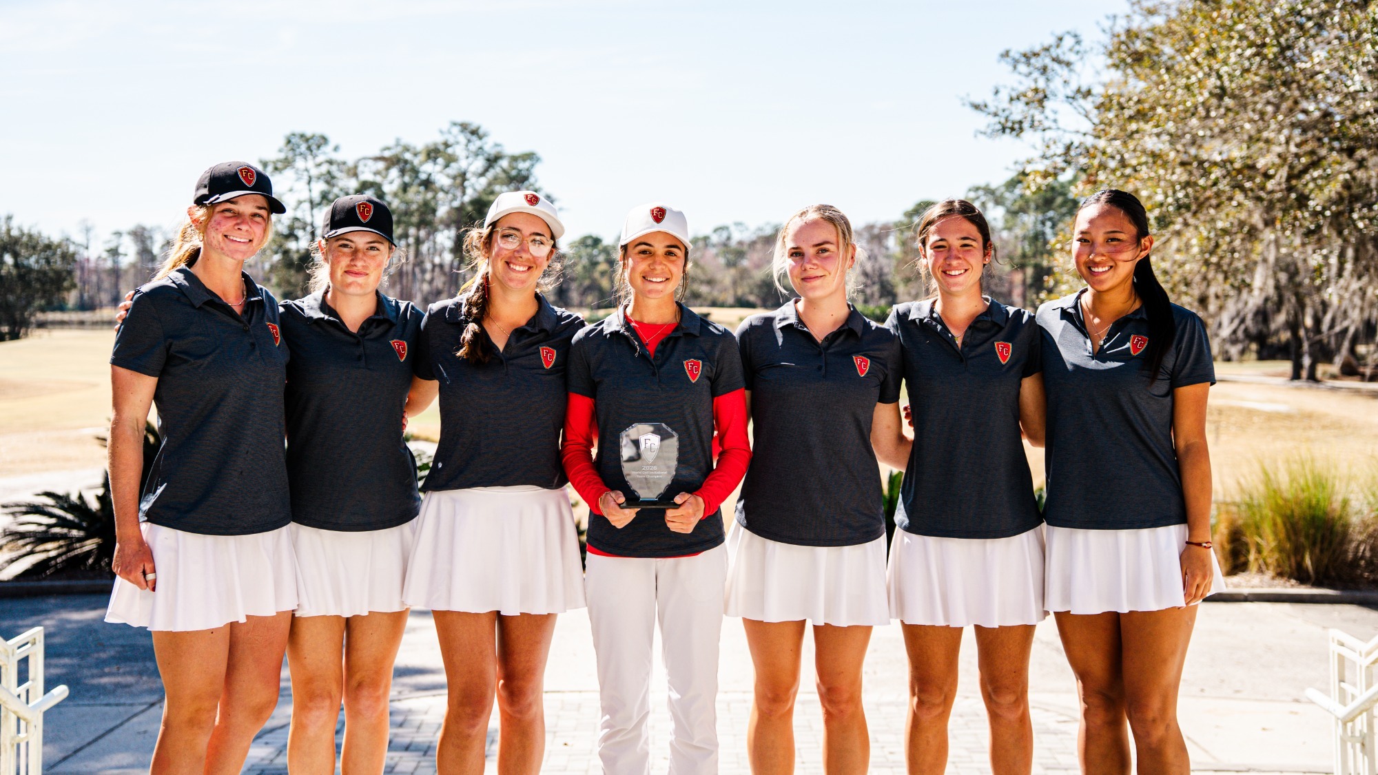 Flagler women's golf team poses with its trophy