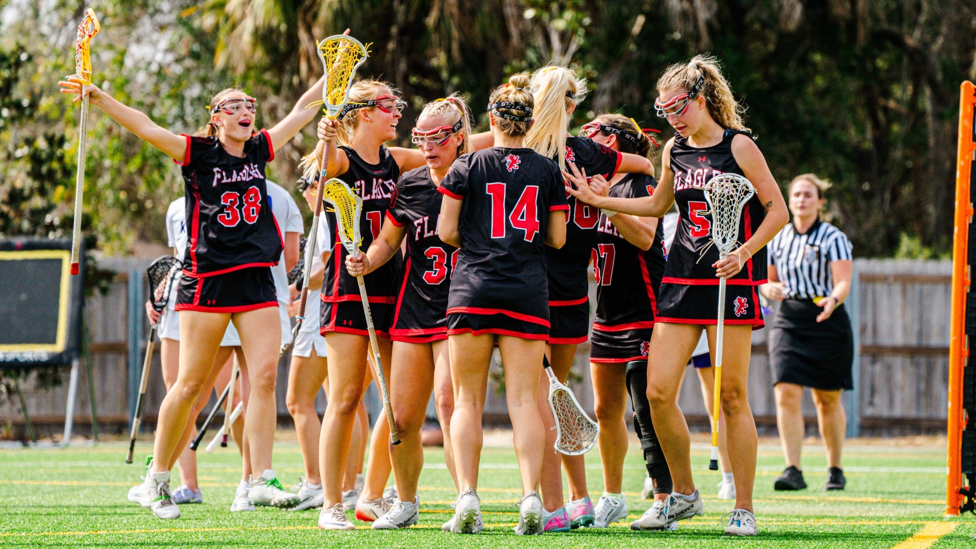Flagler women's lacrosse players celebrate after a goal