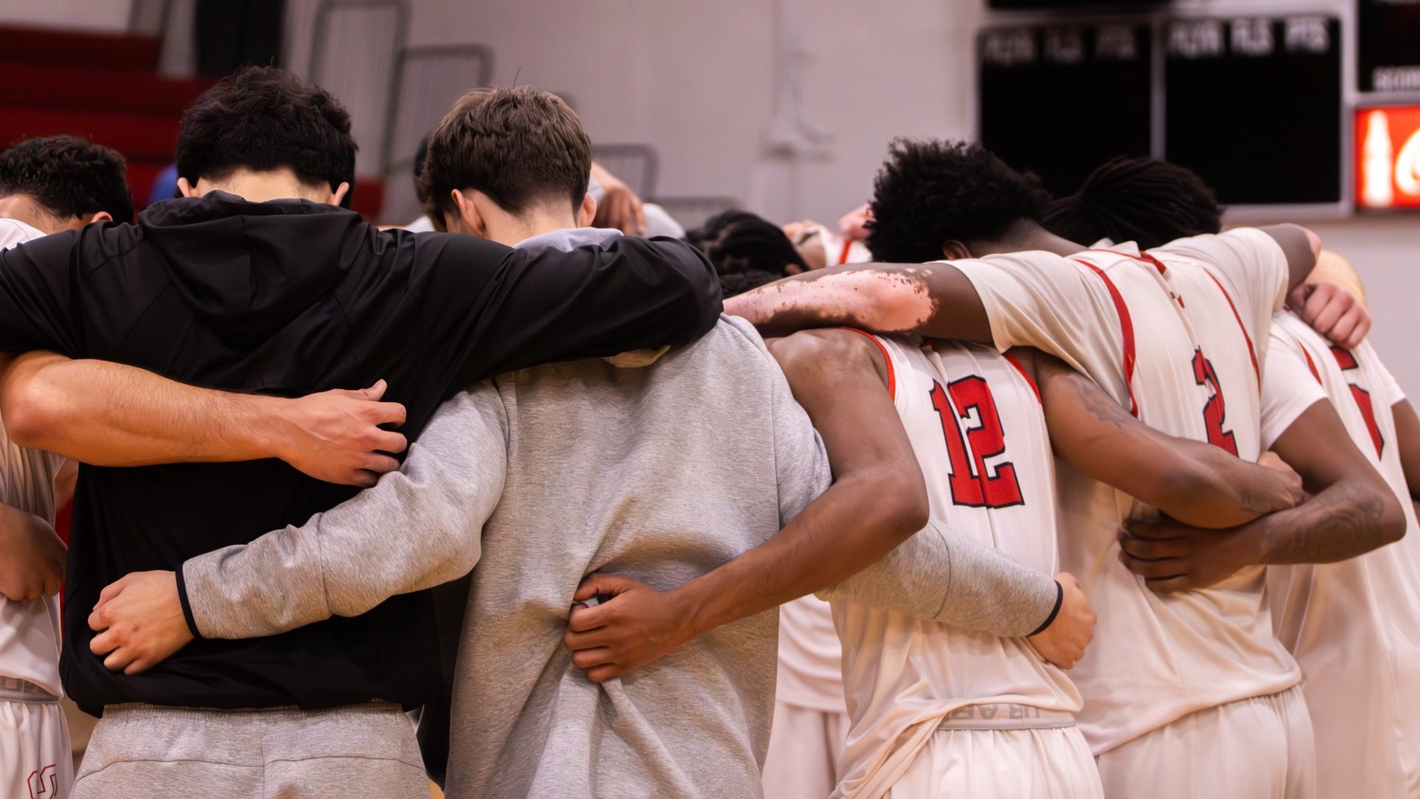 Flagler men's basketball players at halfcourt at a postgame prayer