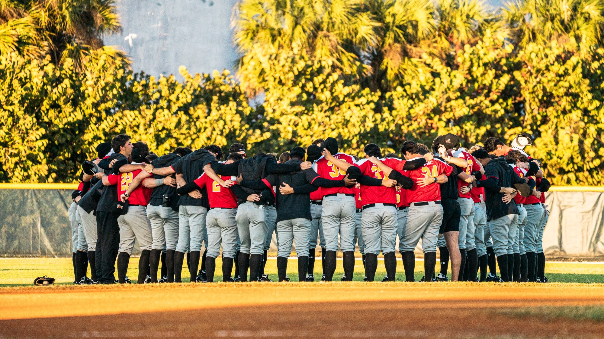 Flagler baseball team meets in the outfield after a game