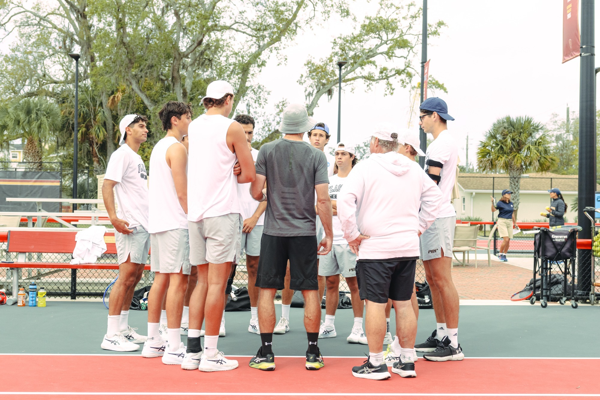 Men's team huddling with the coach