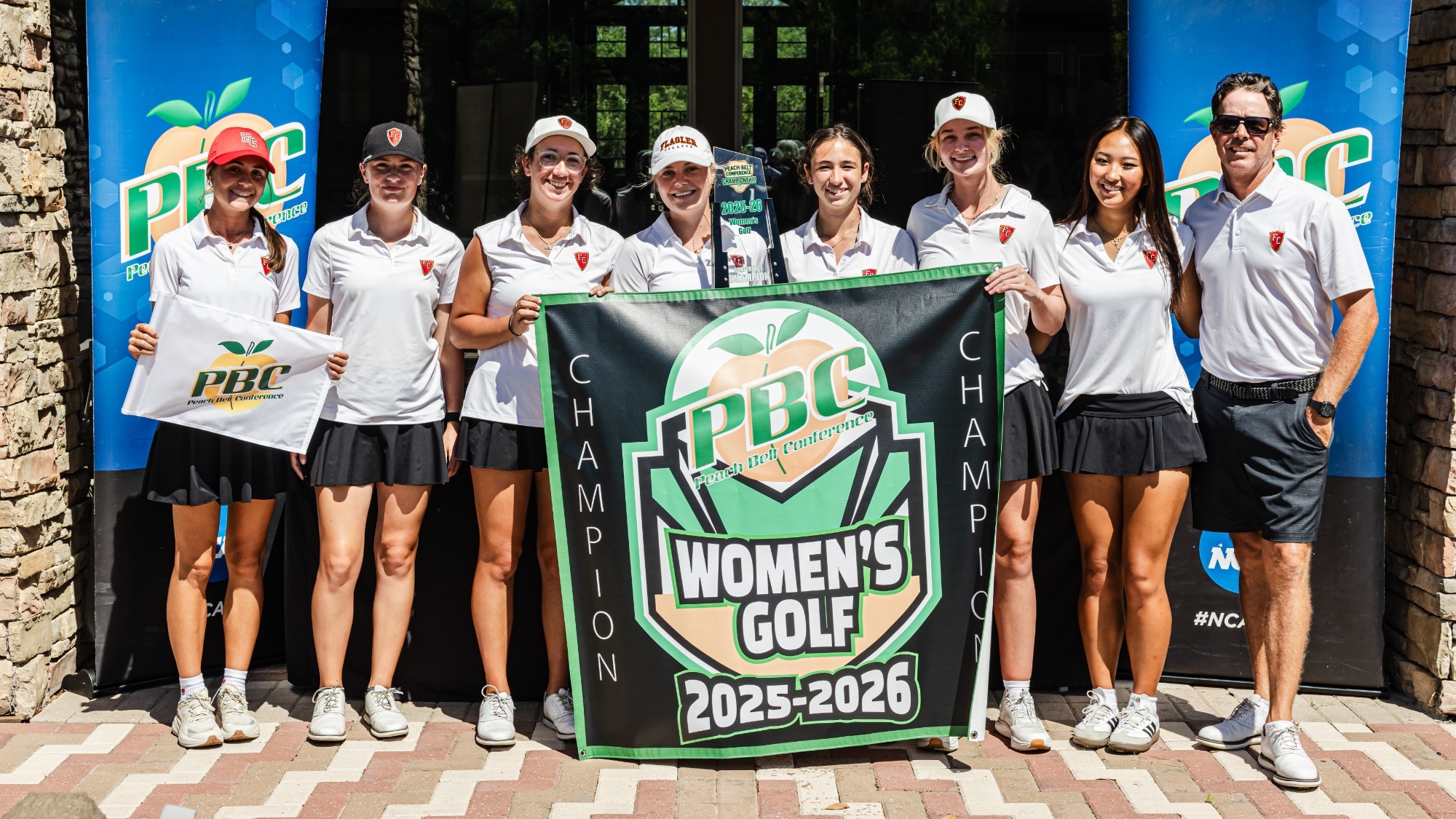 Flagler women's golf team posing with the championship banner and trophy
