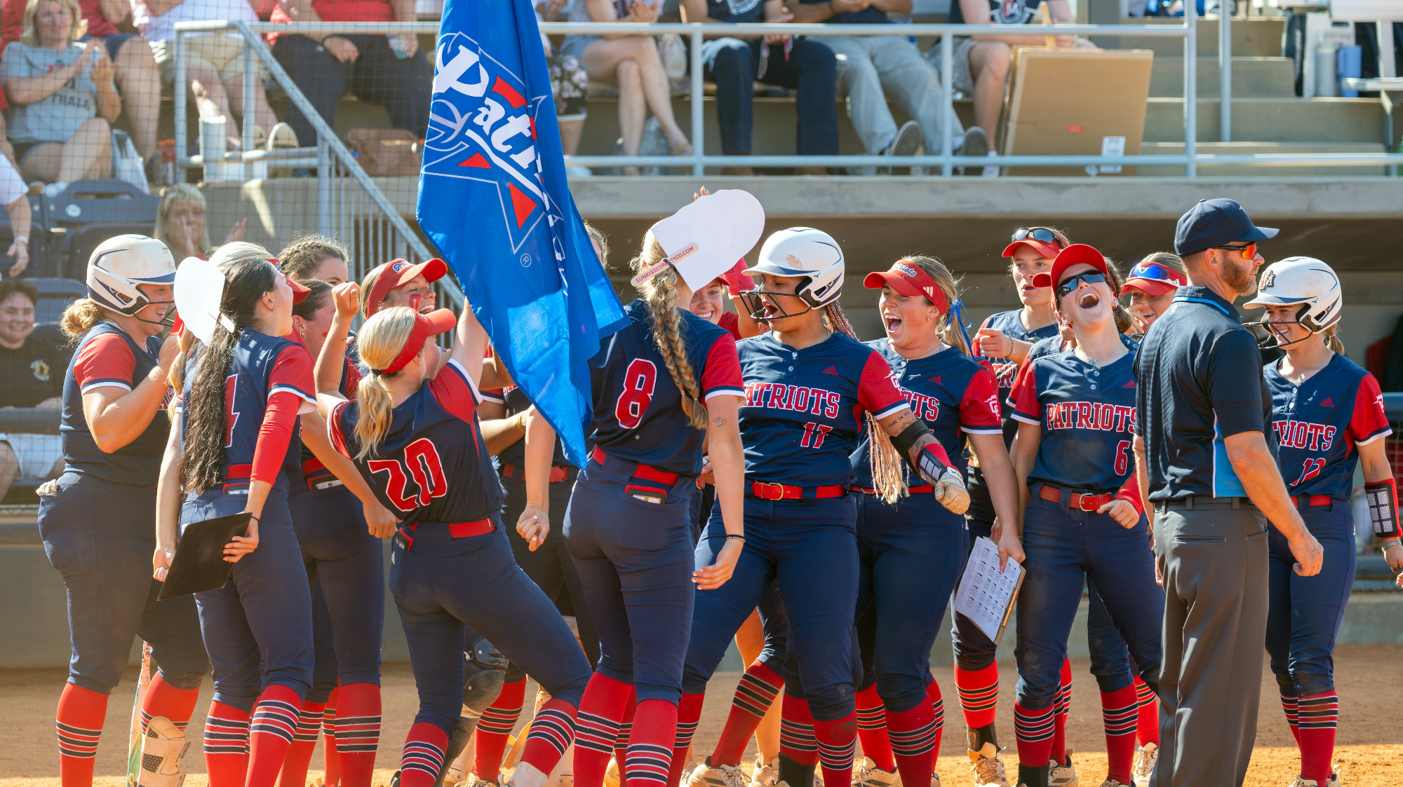 SB26 FMU softball team celebrating a home run at the plate