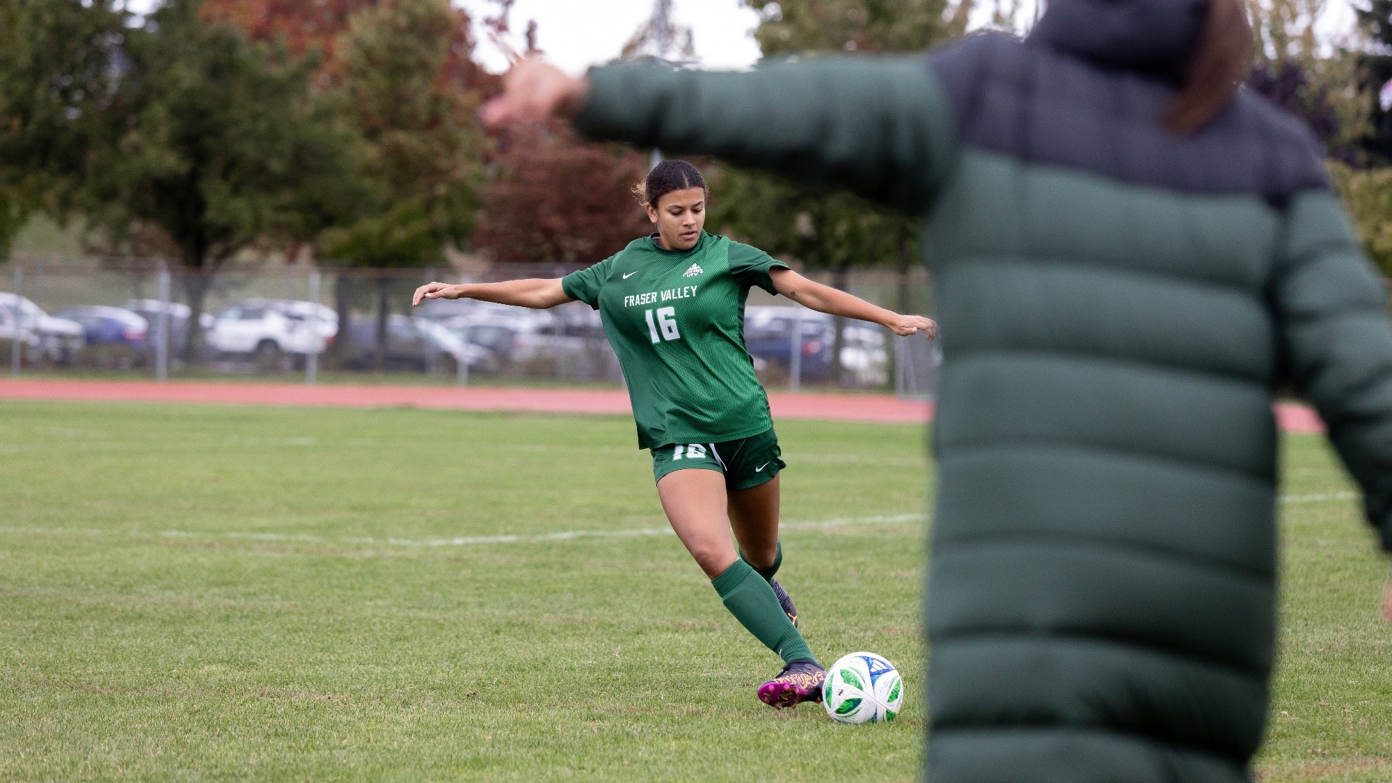 Jaidyn Jackson launches a ball forward as coach Ari directs