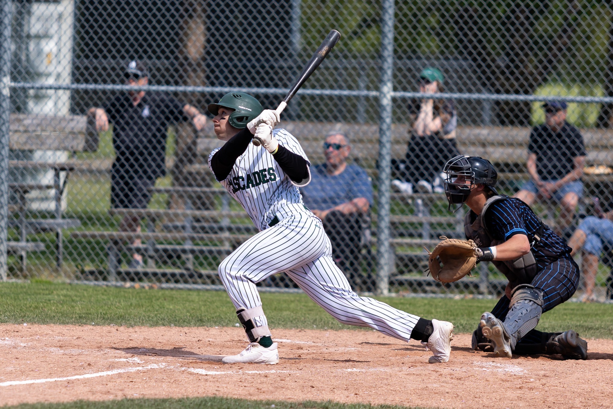 Cascades batter watches a deep fly ball after the hit