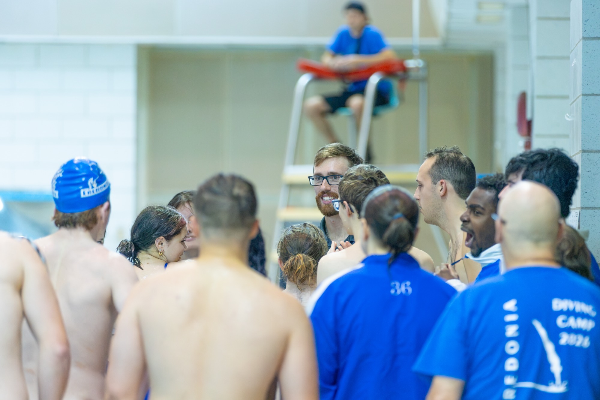 The Fredonia State men's swimming and diving team huddles together