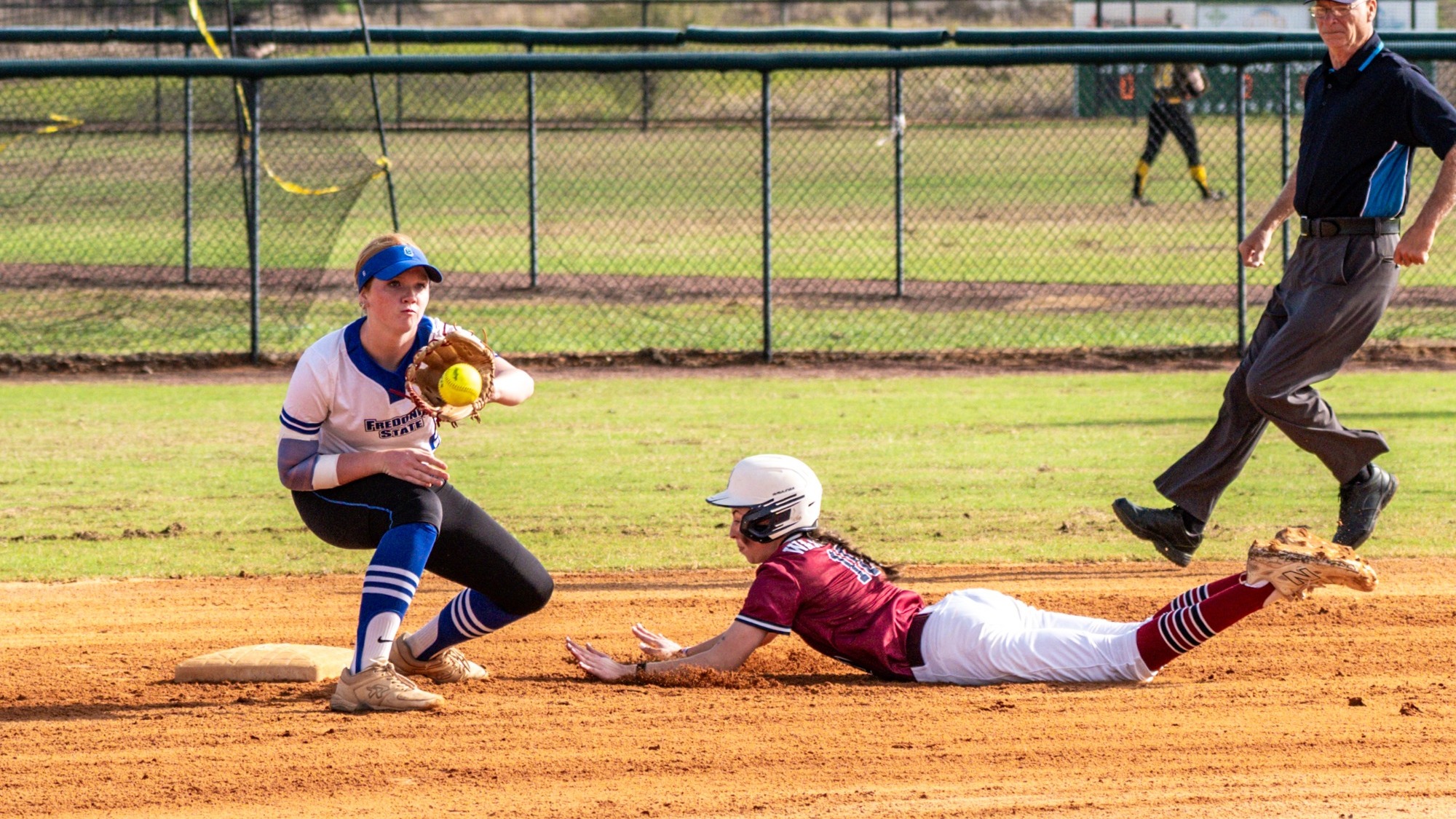 Fredonia State shortstop Madison DeVore takes throw at second base as an opposing runner slides into second and the umpires looks on