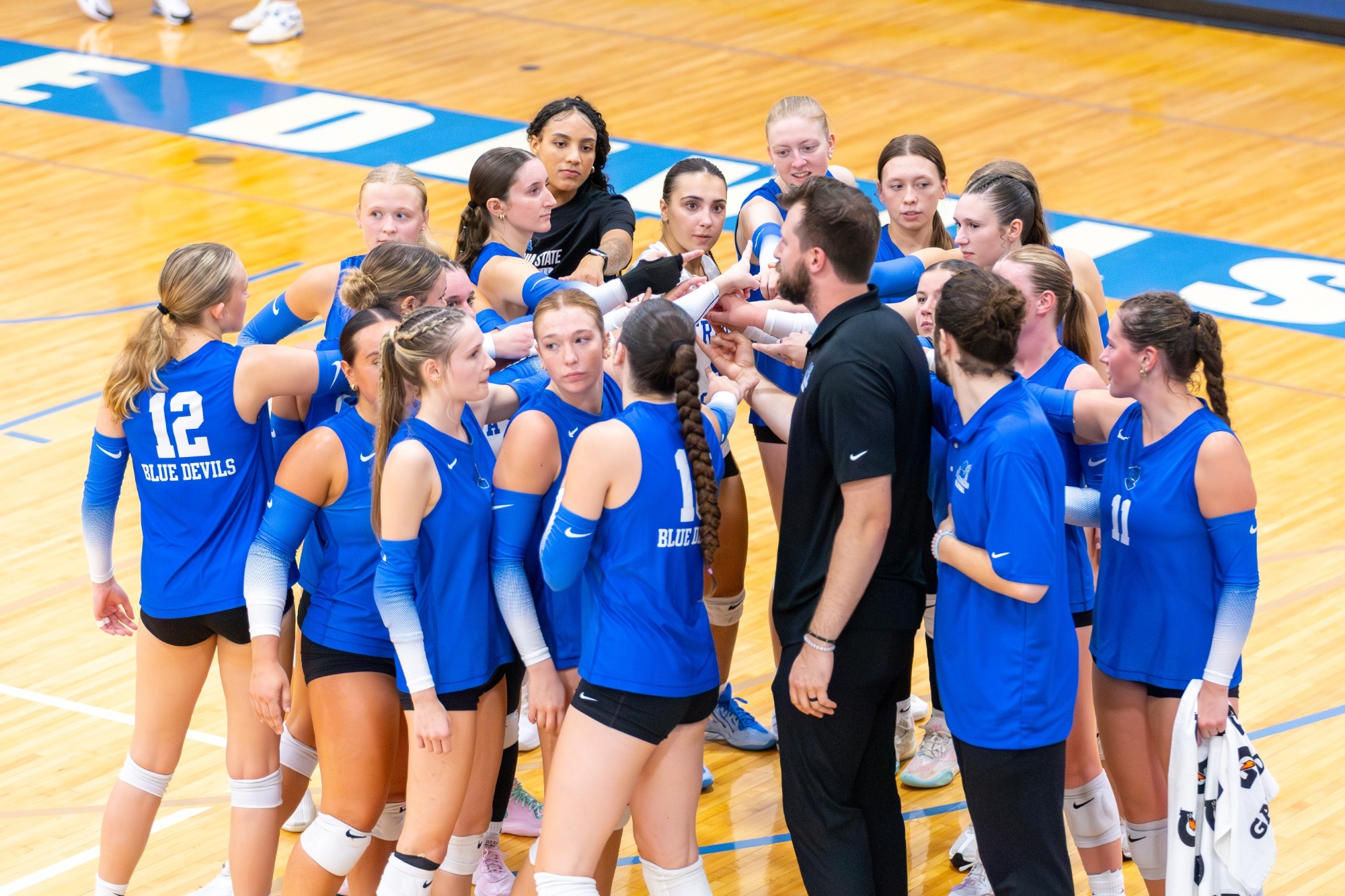 The Fredonia State volleyball team huddles together